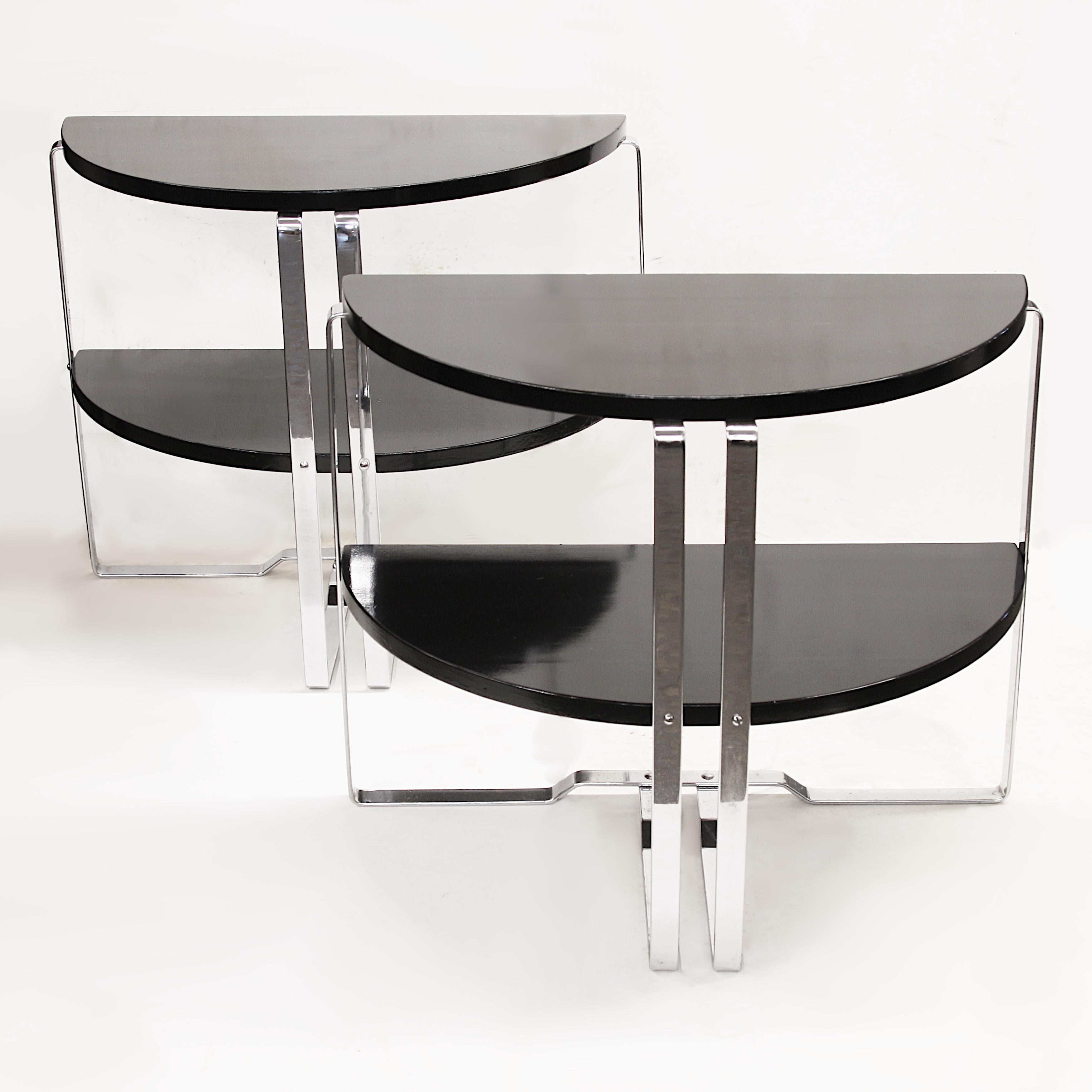 Wonderful set of demilune end tables by Wolfgang Hoffman for Howell.  Tables feature 2 black lacquered, semi-circle shelves,  chrome frames and fantastic Art Deco lines. A rare matching pair with a versatile size that can beautifully mix with Art