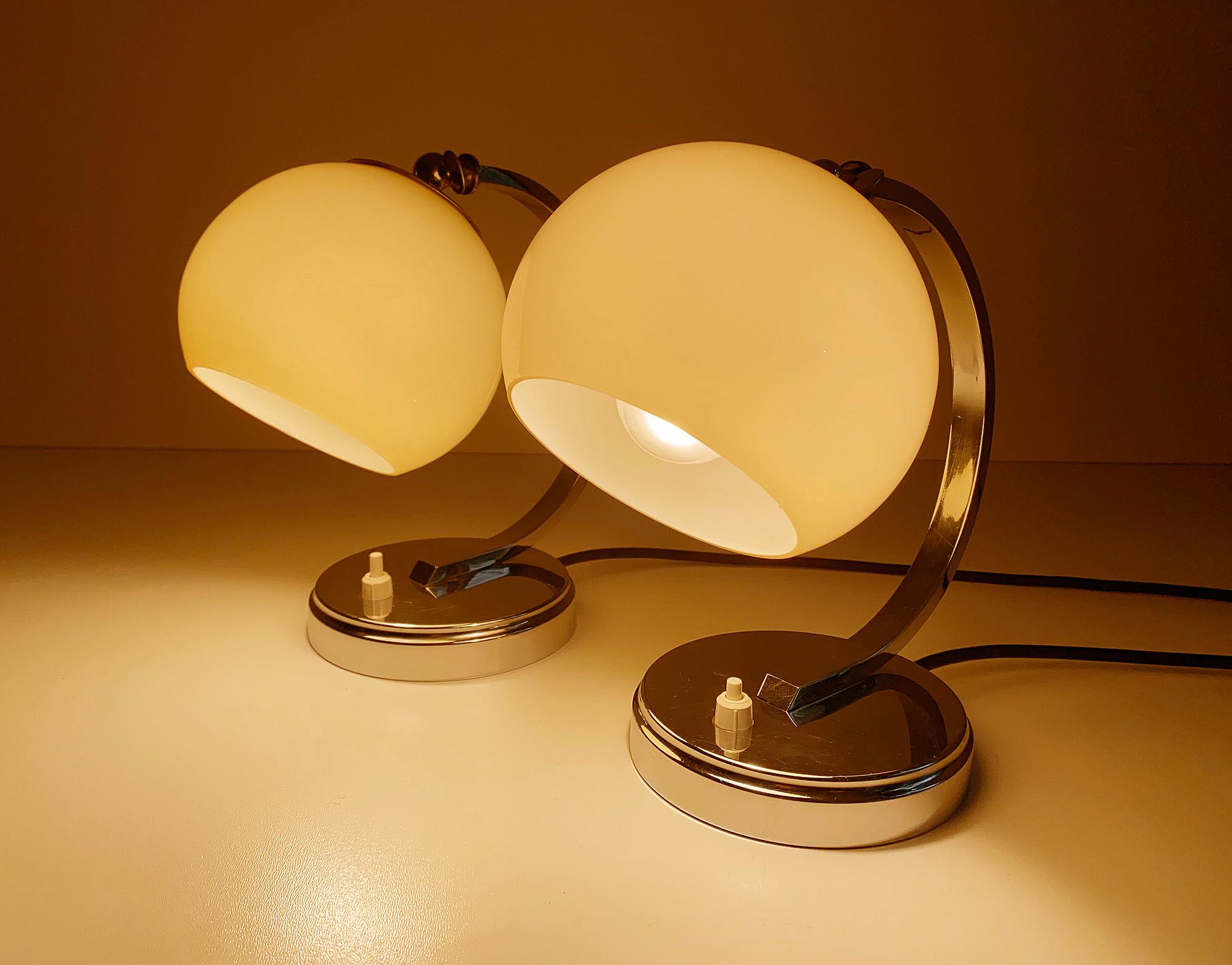 Gorgeous pair of Art Deco table lamps, very high quality design, featuring a round chrome base, half circle craddle with opaline glass shades, the shade’s angle can be adjusted - fully rewired - The lamps have been tested with US American light