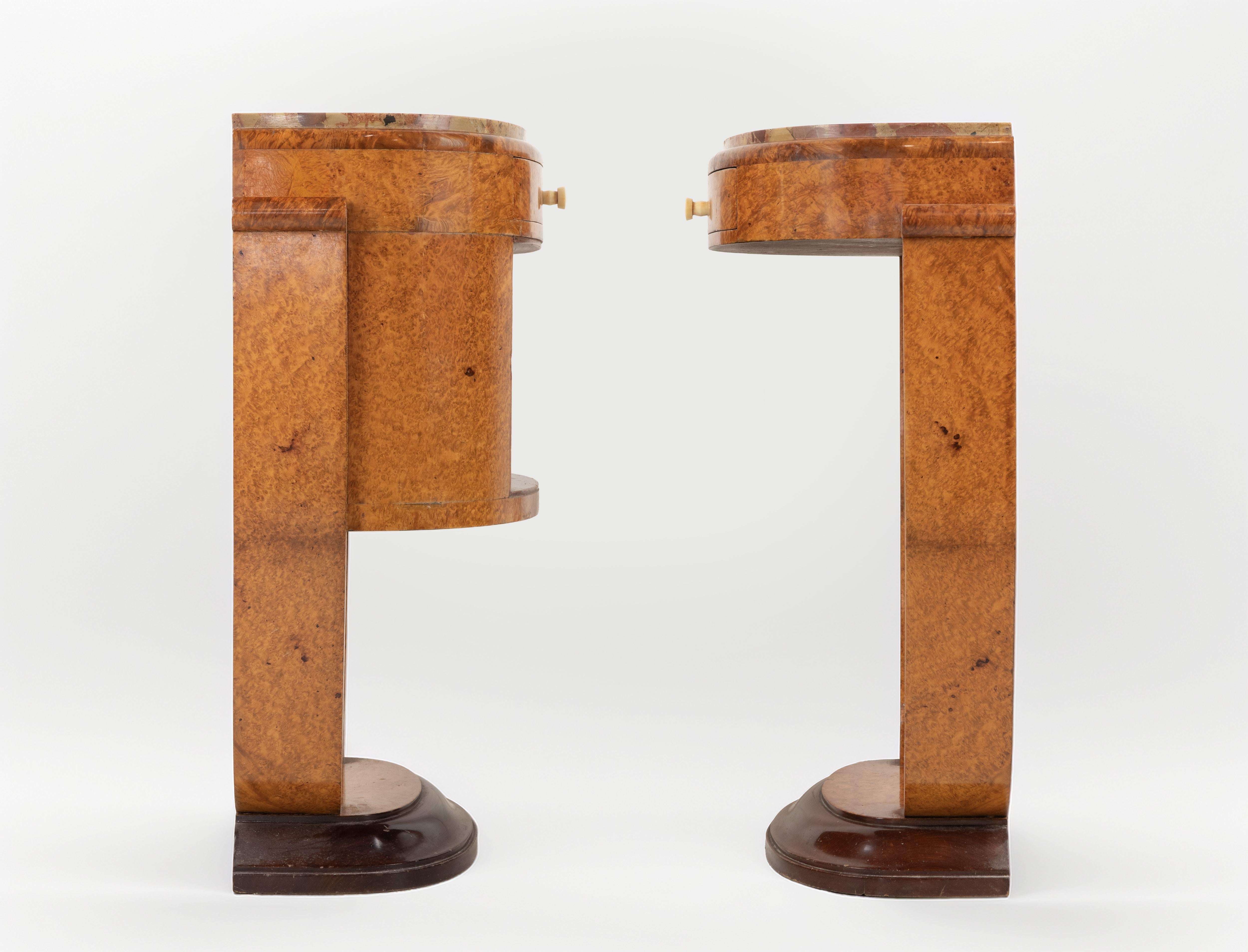 Une magnifique paire de tables de chevet Art Dèco réalisée par Jules Leleu en 1923.

Placage de ronce d'Amboyna, plateaux en marbre Breccia et boutons en laiton ou en os.

Paire de tables de nuit raffinées et sculpturales de style Art-Decor, conçues