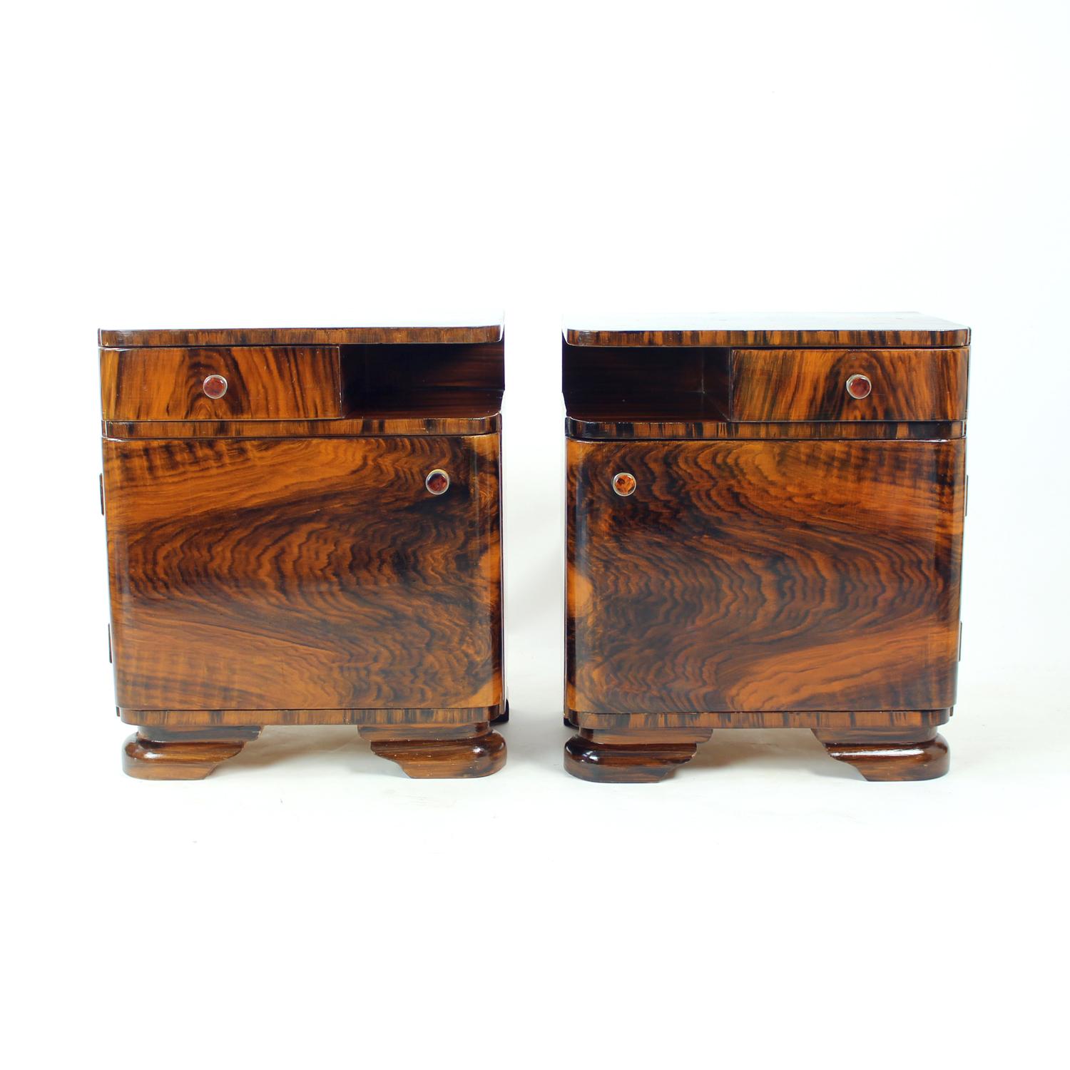 This striking pair of bedside tables was produced in Czechoslovakia during the 1940s, capturing the refined elegance of the late Art Deco period. The design is characterized by its generous proportions (57 cm in height), gently curved corners, and