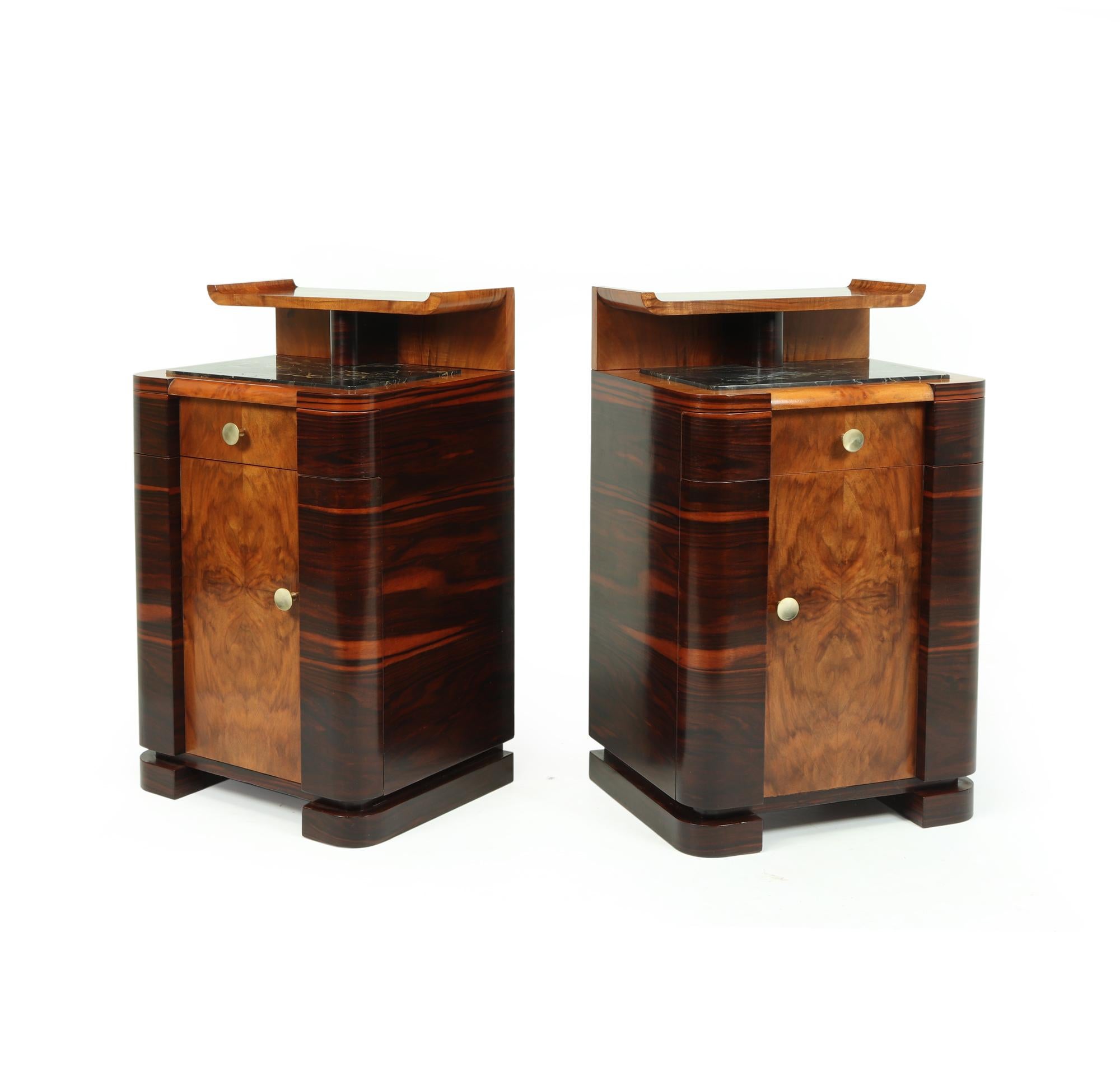 An opposing pair of Art Deco bedside cabinets produced in Italy in the 1930’s, using Macassar ebony and figured walnut, having a single drawer and cupboard below, inset Portoro marble tops with a Chinese influenced up-stand to the back

The