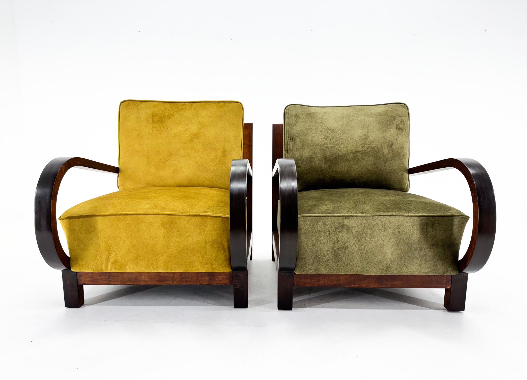 Set of two art deco armchairs. The wooden parts have been carefully restored. The armchairs are newly upholstered in velvet fabric. The cushions can be easily interchanged so you can combine the two colours.

