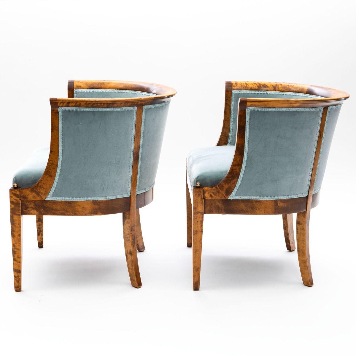 A pair of elegant Art Deco bergère-style armchairs with a rounded back, crafted from flamed birch wood.
The chairs feature tapered front legs, adorned with round brass knobs at the top, and gently curved back legs.
Attributed :
Bent Helveg-Møller