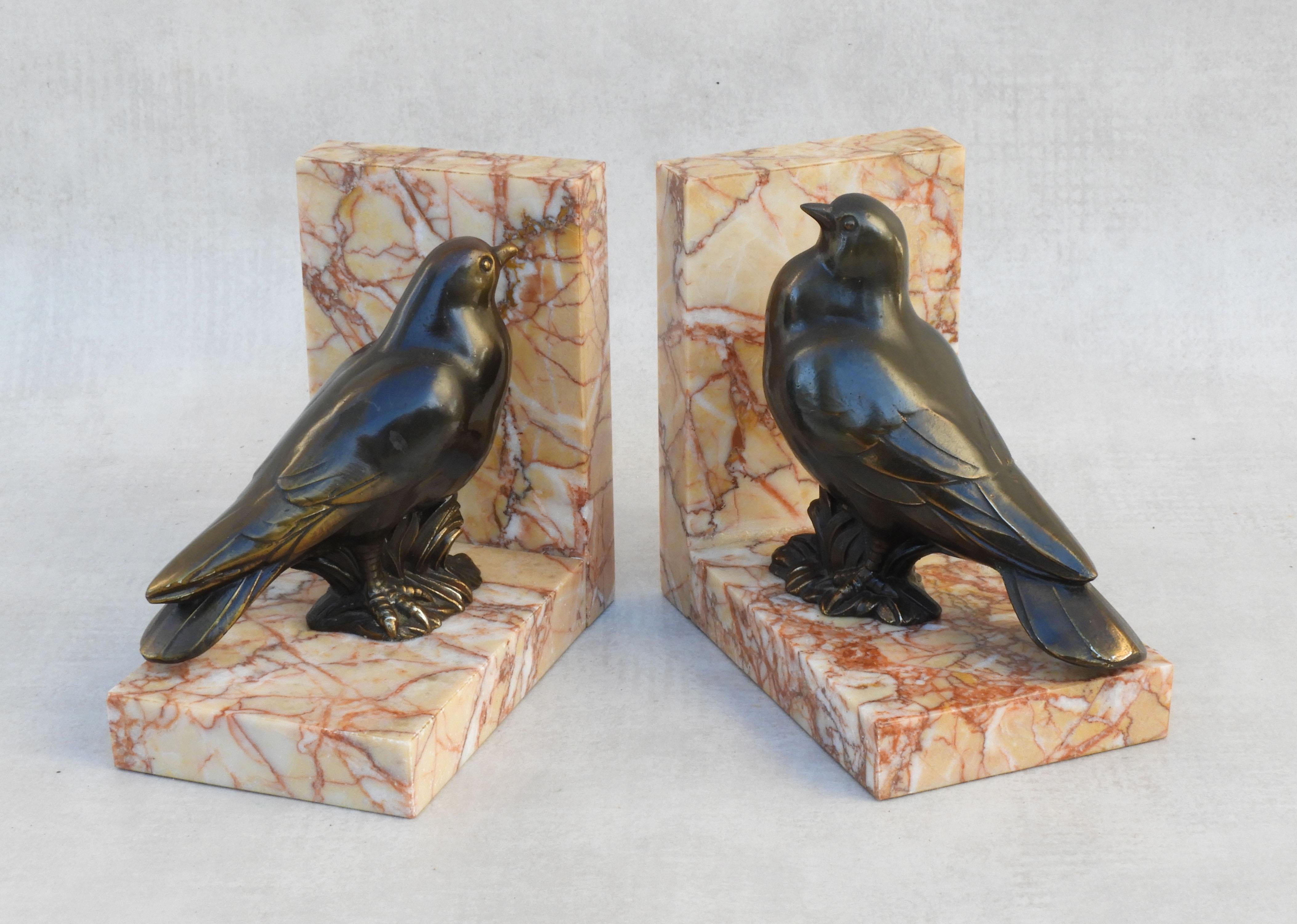 A delightful pair of French Art Deco bird book ends C1930s.  A charming male and female couple in bronze patinated spelter perched on marble L-shaped plinths. In good vintage condition with nice patina. 

Dimensions: height: 4.72 in. (12 cm) width: