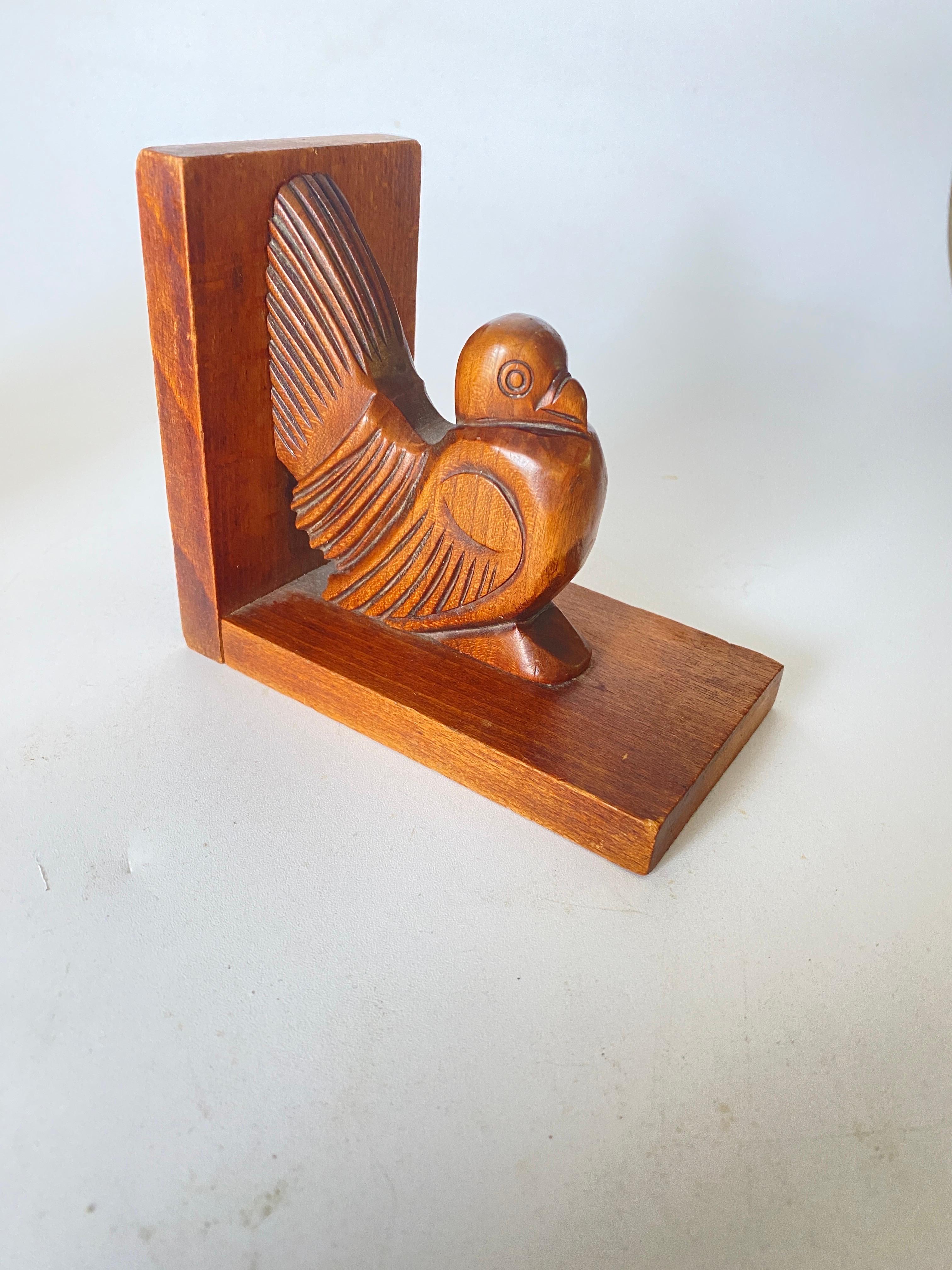 Pair of bookends representing birds. The objects are in wood. These bookends were made in France in the 1940s, they are typical objects from the Art Deco period. It is signed.