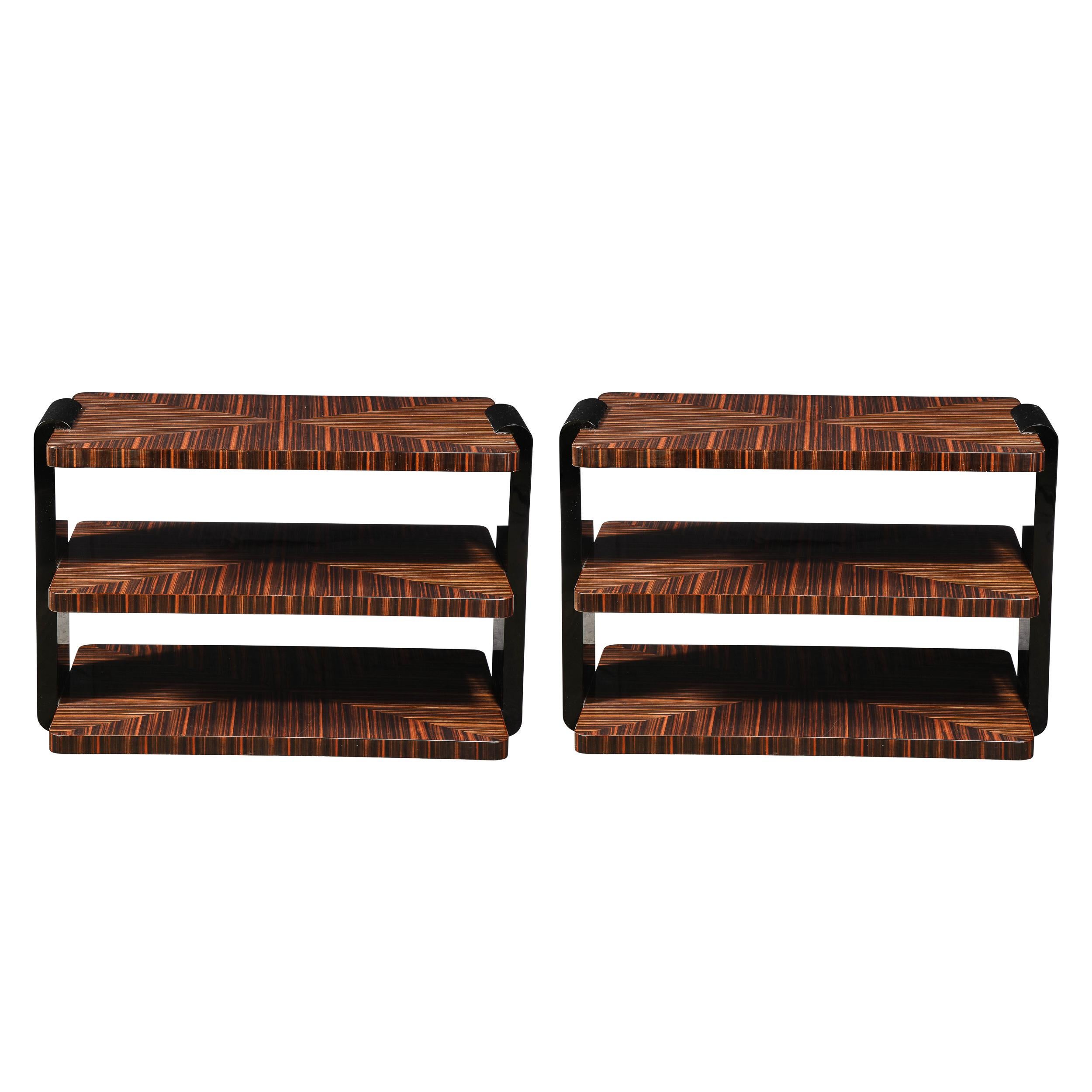 This stunning pair of Art Deco three tier occasional tables were realized in France circa 1930. They feature three rectangular table tops with rounded corners in beautiful bookmatched Macassar attached by two streamlined black lacquer supports