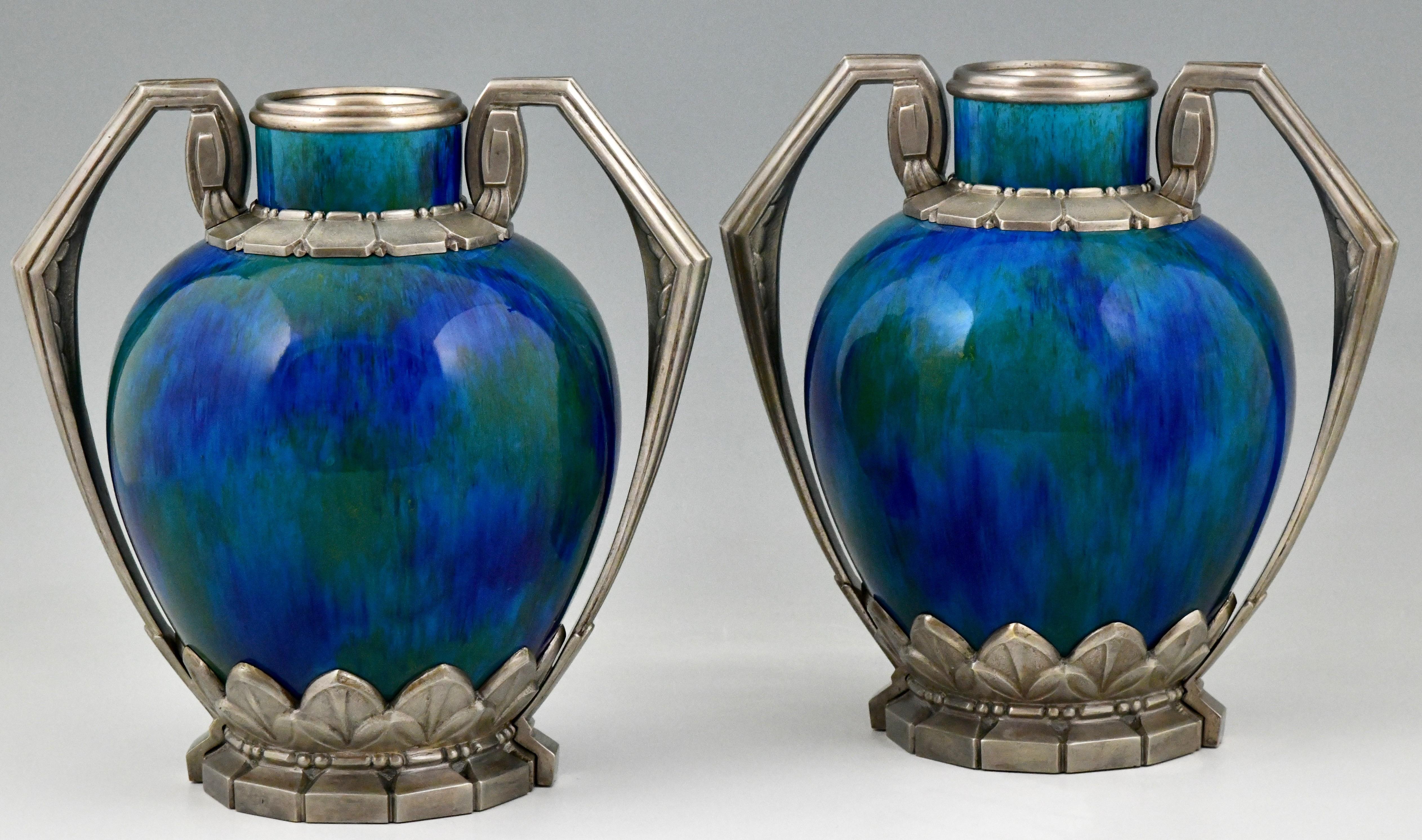 A pair of French Art Deco ceramic vases with ��“blue flambé” glaze and silvered bronze mounts.
There are gold specks in the intense colored green/blue glaze.
Designed by Paul Milet (1870-1950) for Sèvres, France, 1920. 
Marked: MP and Sèvres dotted