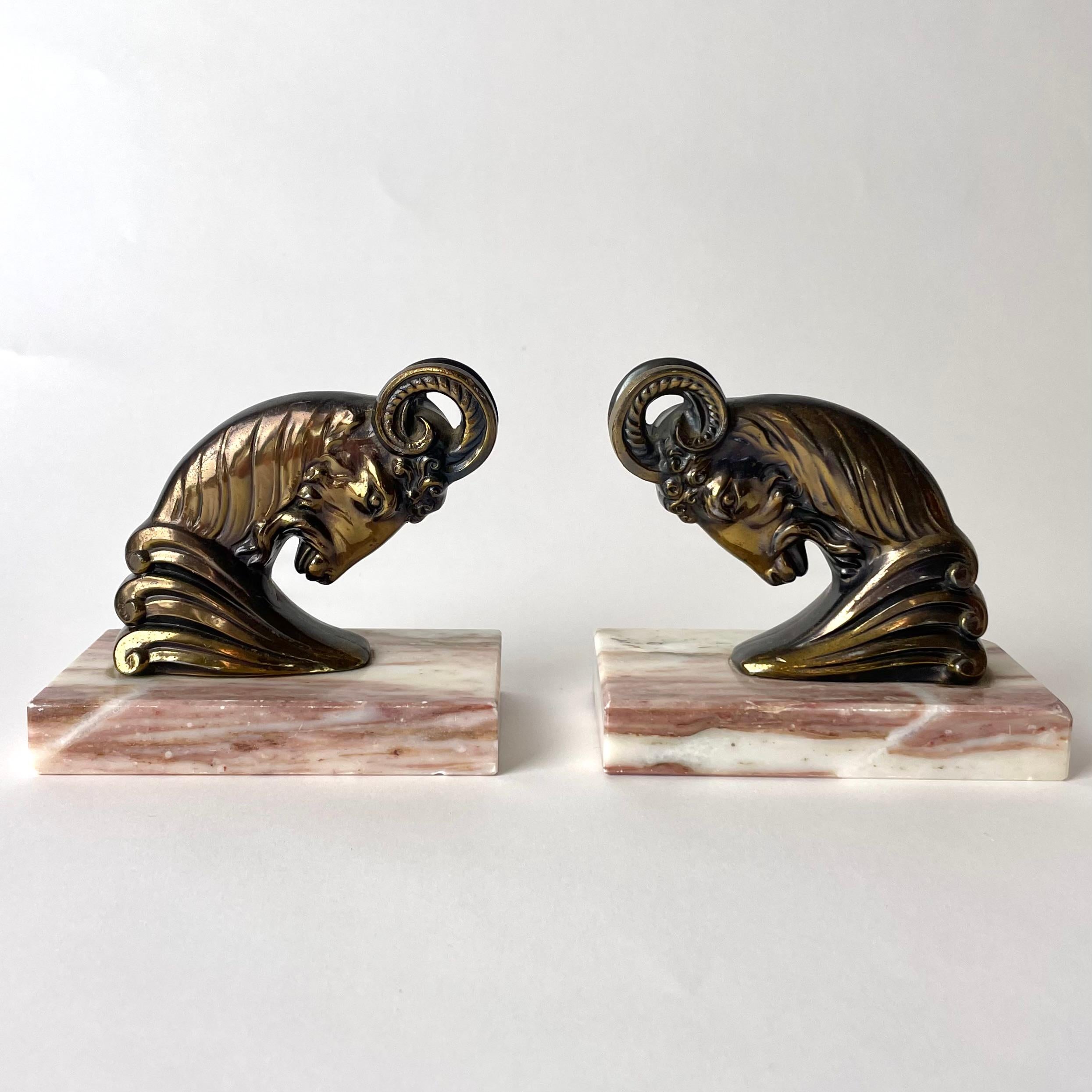 A Pair of powerful Art Deco Bookends from the 1930s with very period designed rams. Made in patinated metal with marble bases.

Wear consistent with age and use 