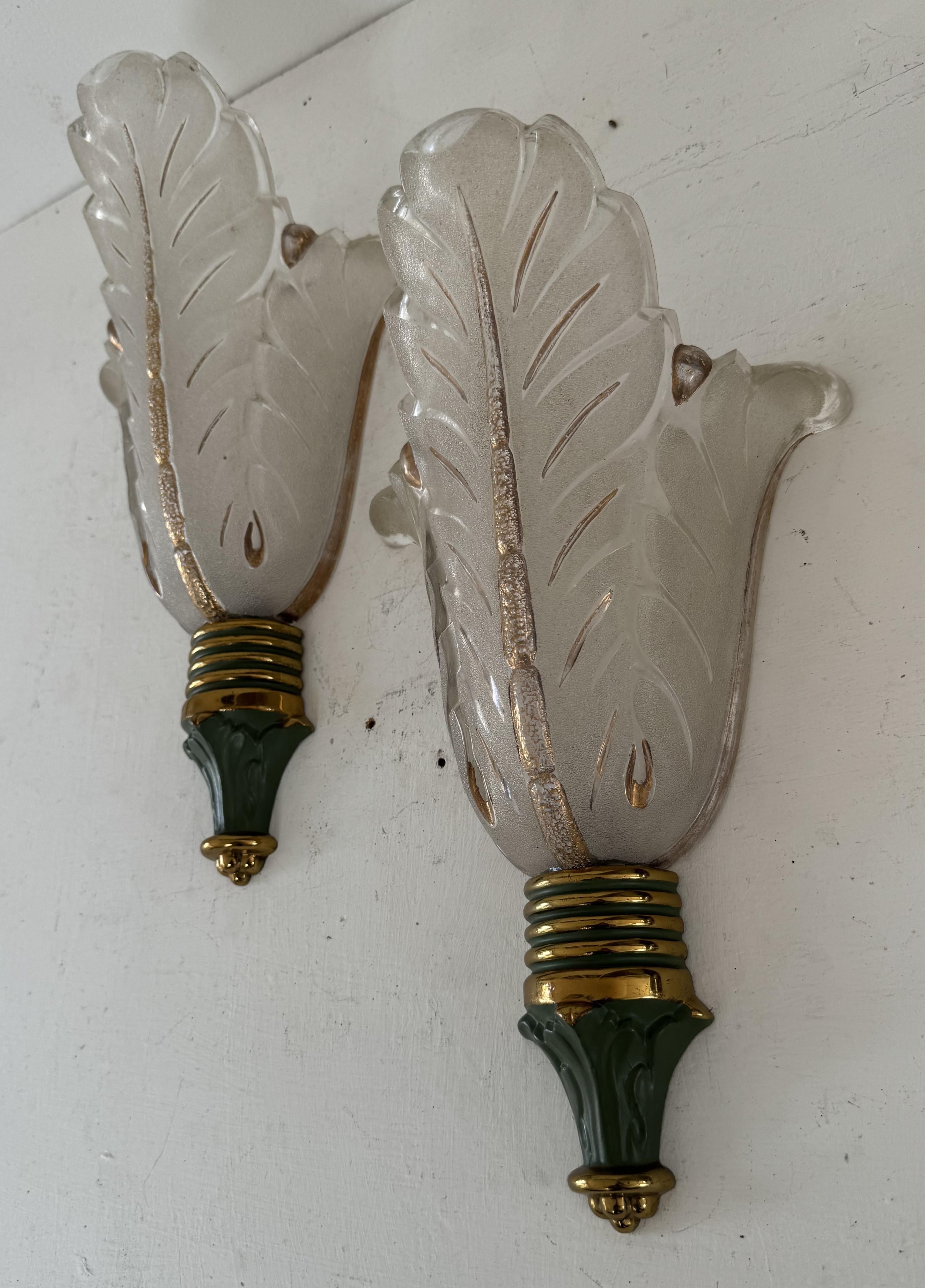 Coppia di appliques Art Deco in vetro pressato e bronzo prodotte da Ezan in Francia intorno agli anni '40, caratterizzate da un bellissimo disegno di palme.
Sulle tonalità del vetro è stampigliato 