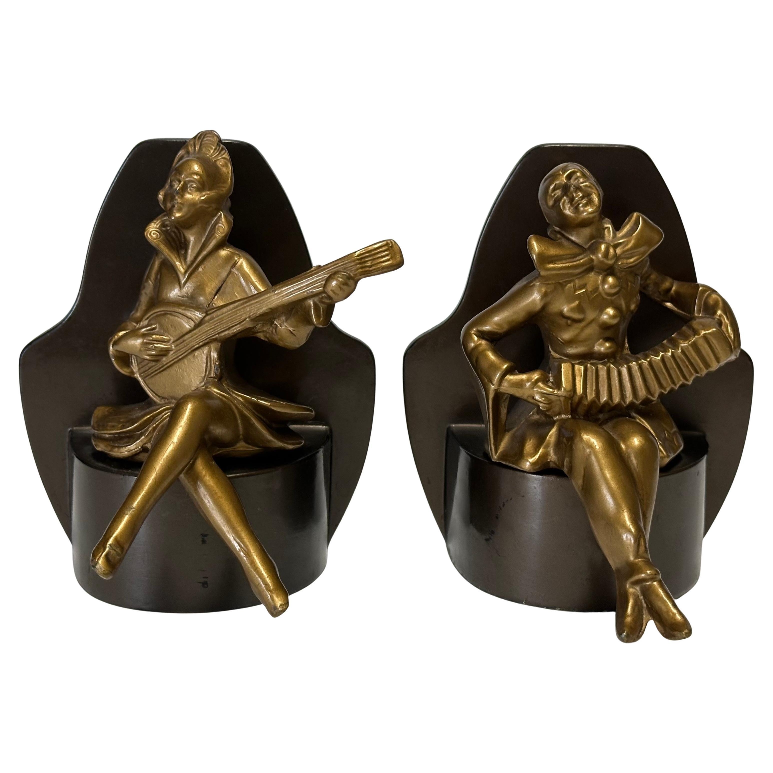 Coppia di reggilibri in ottone Art Deco Arlecchino o Clown musicista su base in metallo