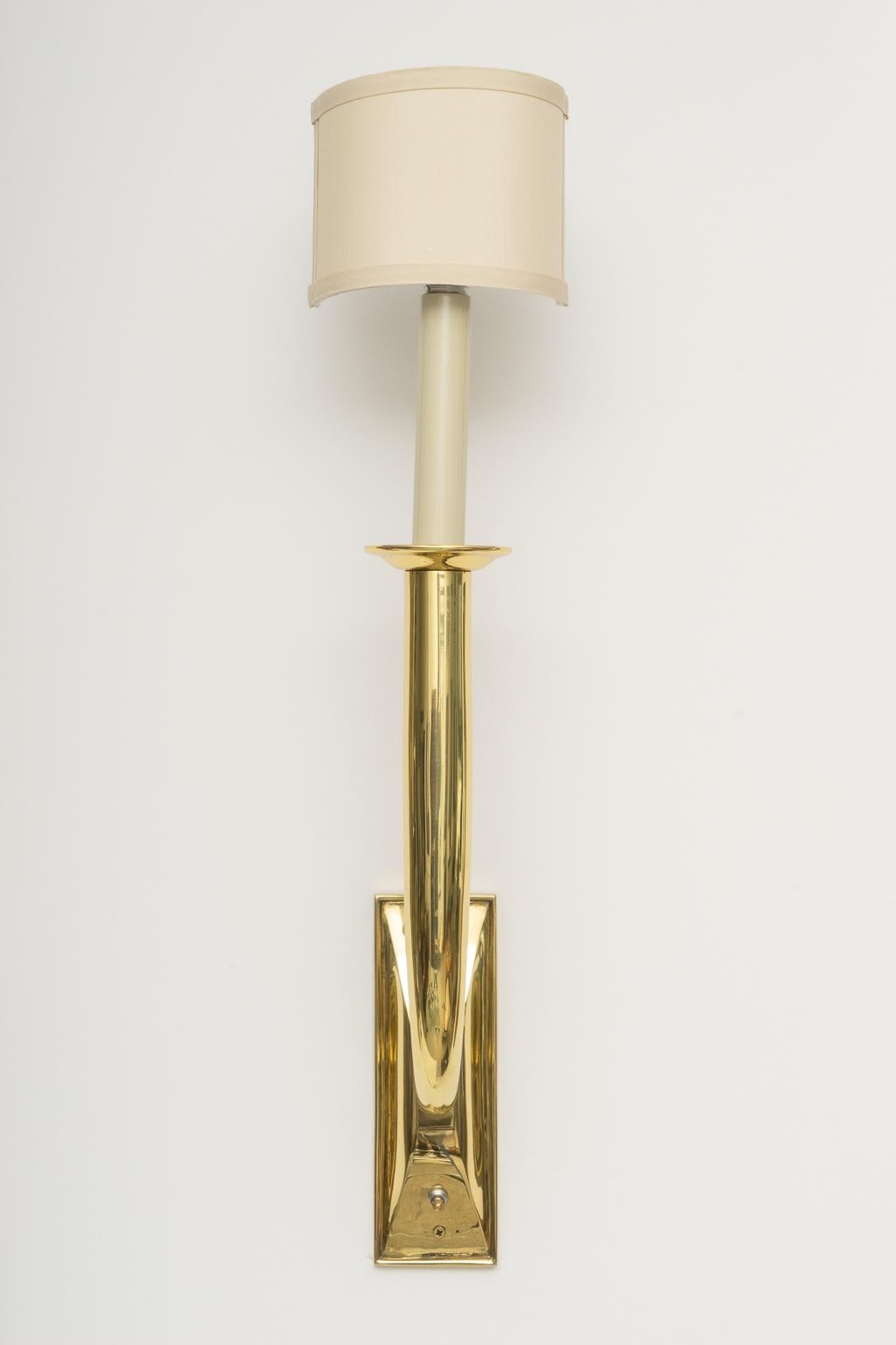 This stylish set of brass Art Deco sconces are very much in the style of pieces created by Jules Leleu and they date to the 1930s-1940s. 

Note: Height to the top of the socket is 24