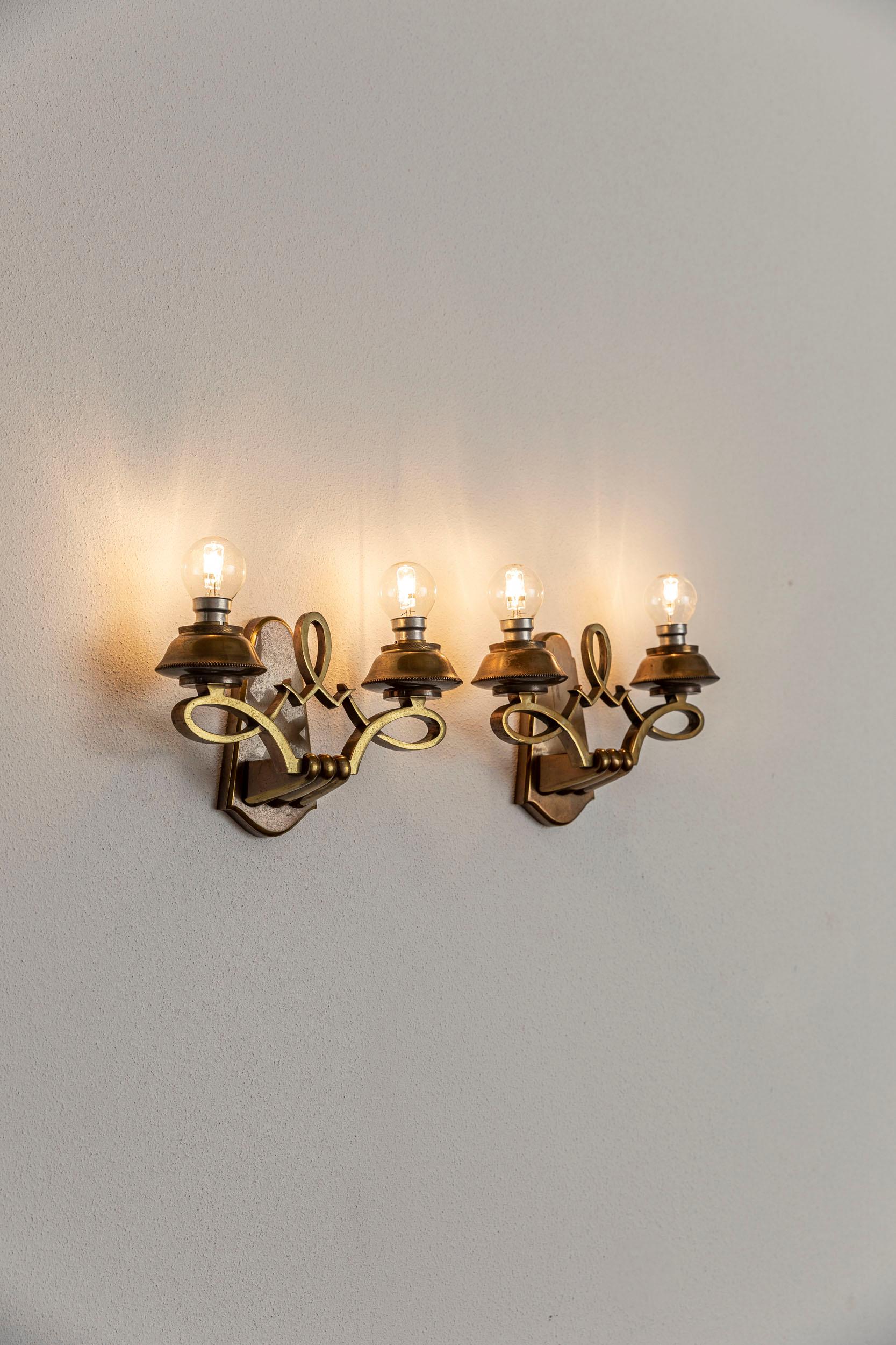 Very elegant pair of double brass Art Deco French sconces, in the style of Jules Leleu, c. 1950
This wall sconces present the characteristic oxidized brass decoration.