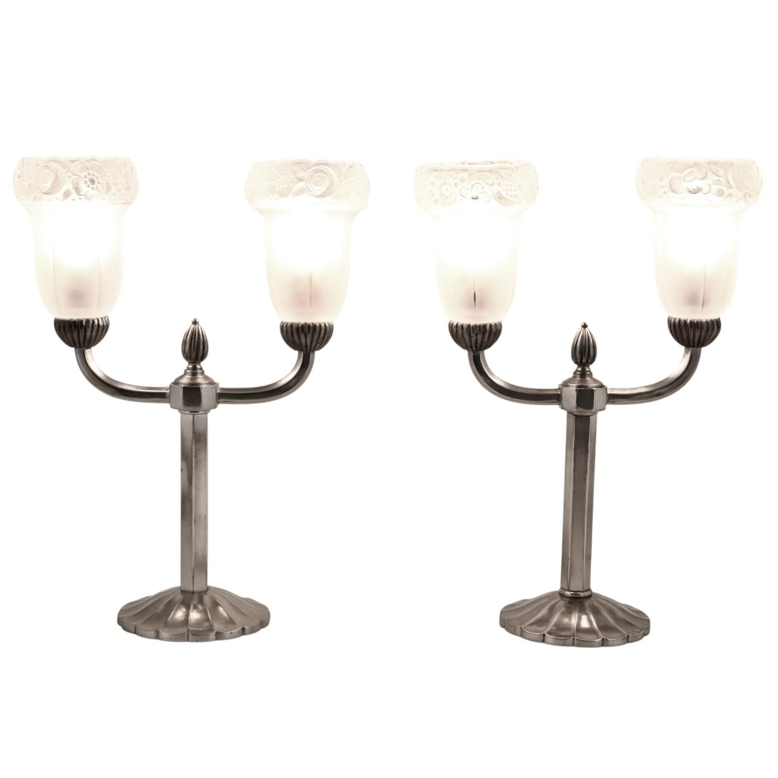 Coppia di lampade in bronzo Art Deco.
Bronzo, patina d'argento. 
Paralumi in vetro pressato con fiori. 
Francia 1930. 
