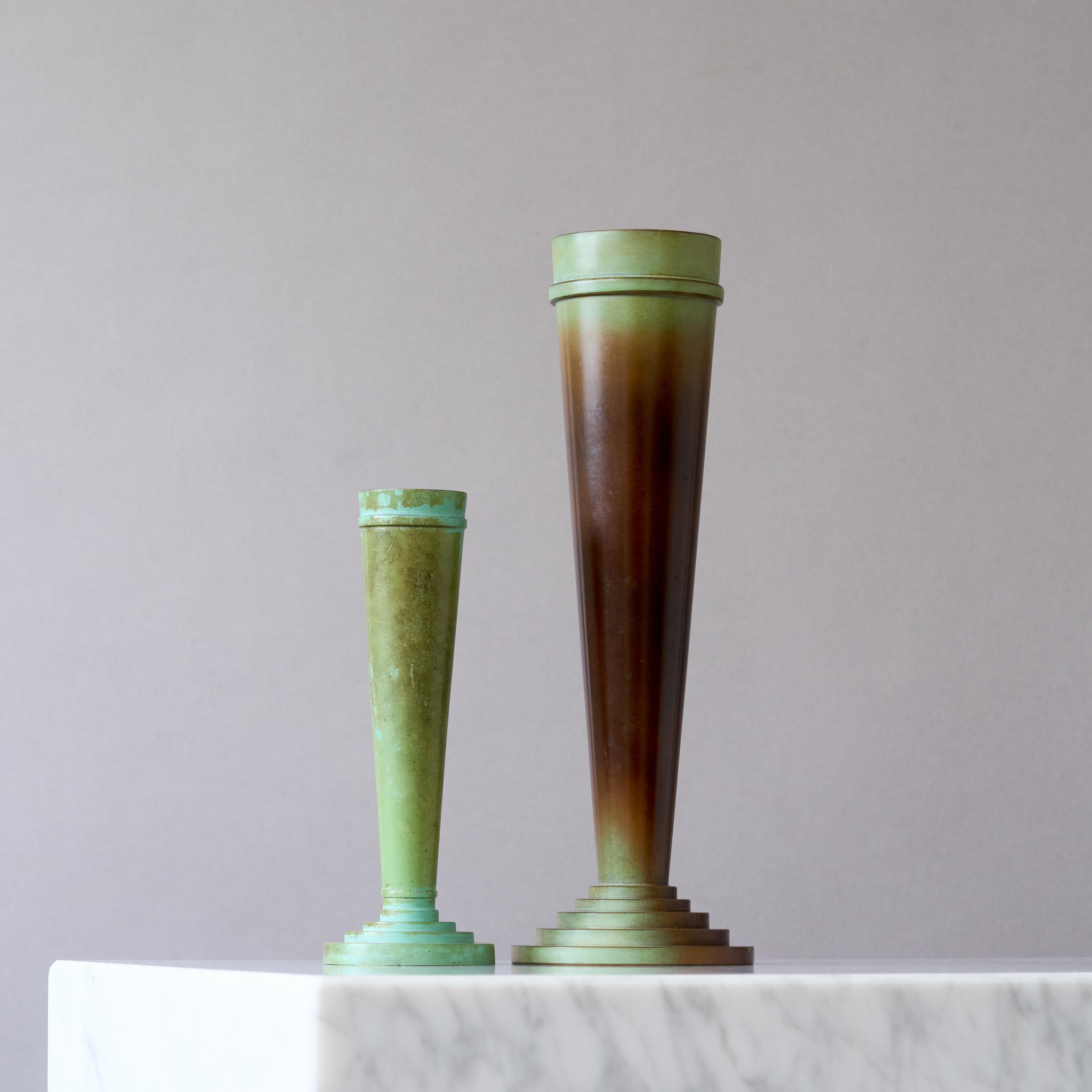 Una coppia di bellissimi vasi in bronzo Art déco / Swedish Grace con una patina incredibile. 
Realizzata da Ystad Brons / Metall, Svezia, anni '30.

Buone condizioni. Alcuni segni di usura nella patinatura e alcuni graffi. Il vaso più alto ha una