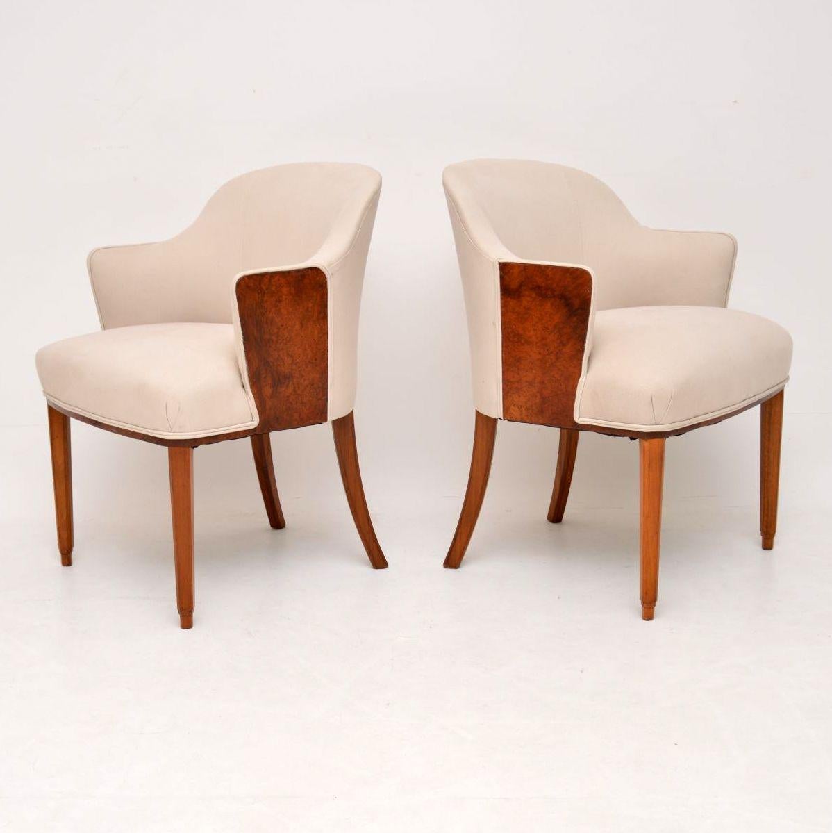 Stylish pair of original Art Deco armchairs dating from the 1920s-1930s period, in excellent condition having just been French polished and re-upholstered in a neutral colored fabric. They have burr walnut panels on the sides of the arms and solid