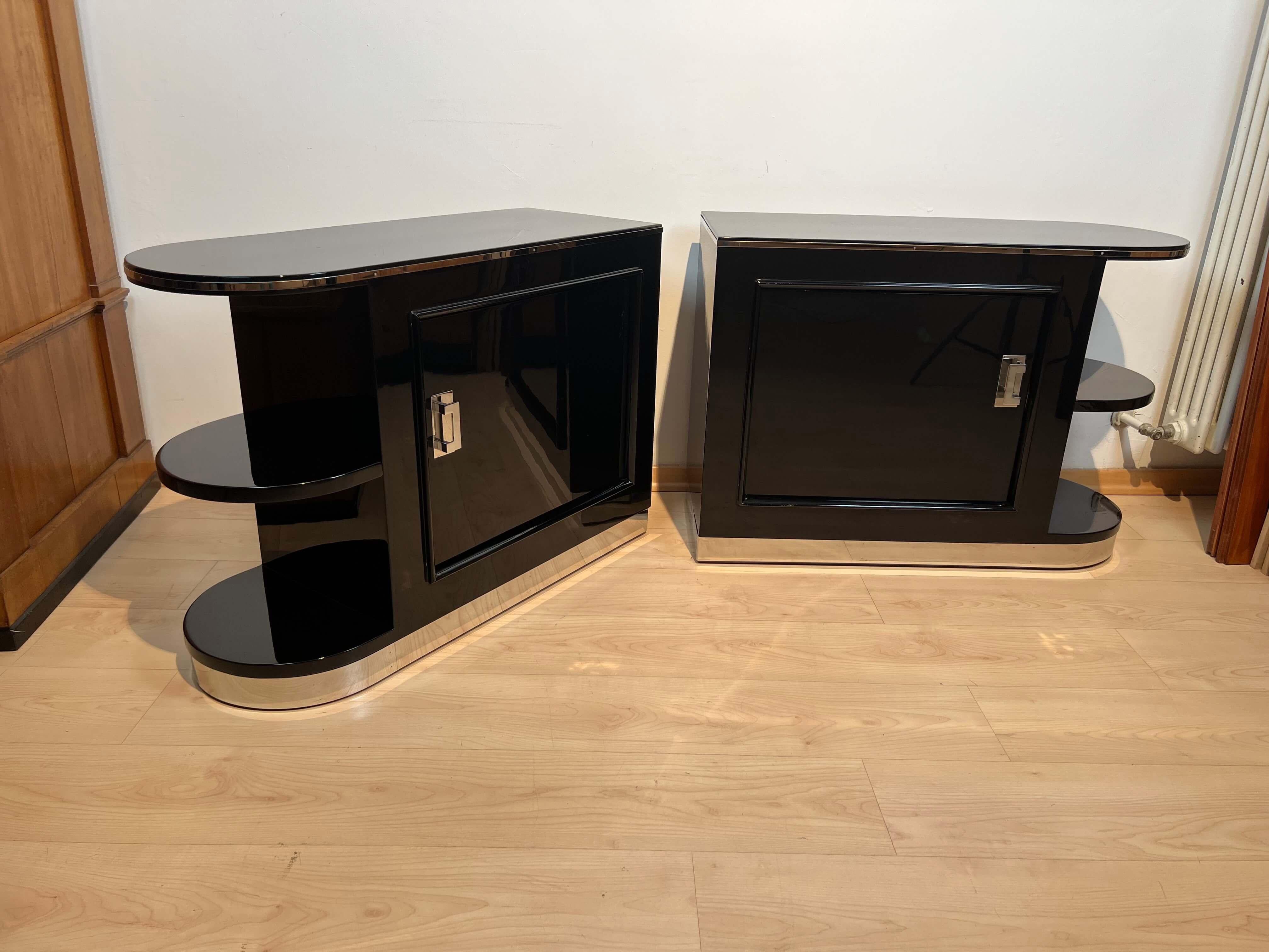 Pair of Art Deco cabinets / nightstands, black lacquer, metal, maple, France circa 1930.

Walnut, high-gloss black lacquered. Asymmetrical shape (round + straight) with shelves on the rounded side.
Door on one long side, compartment with shelf