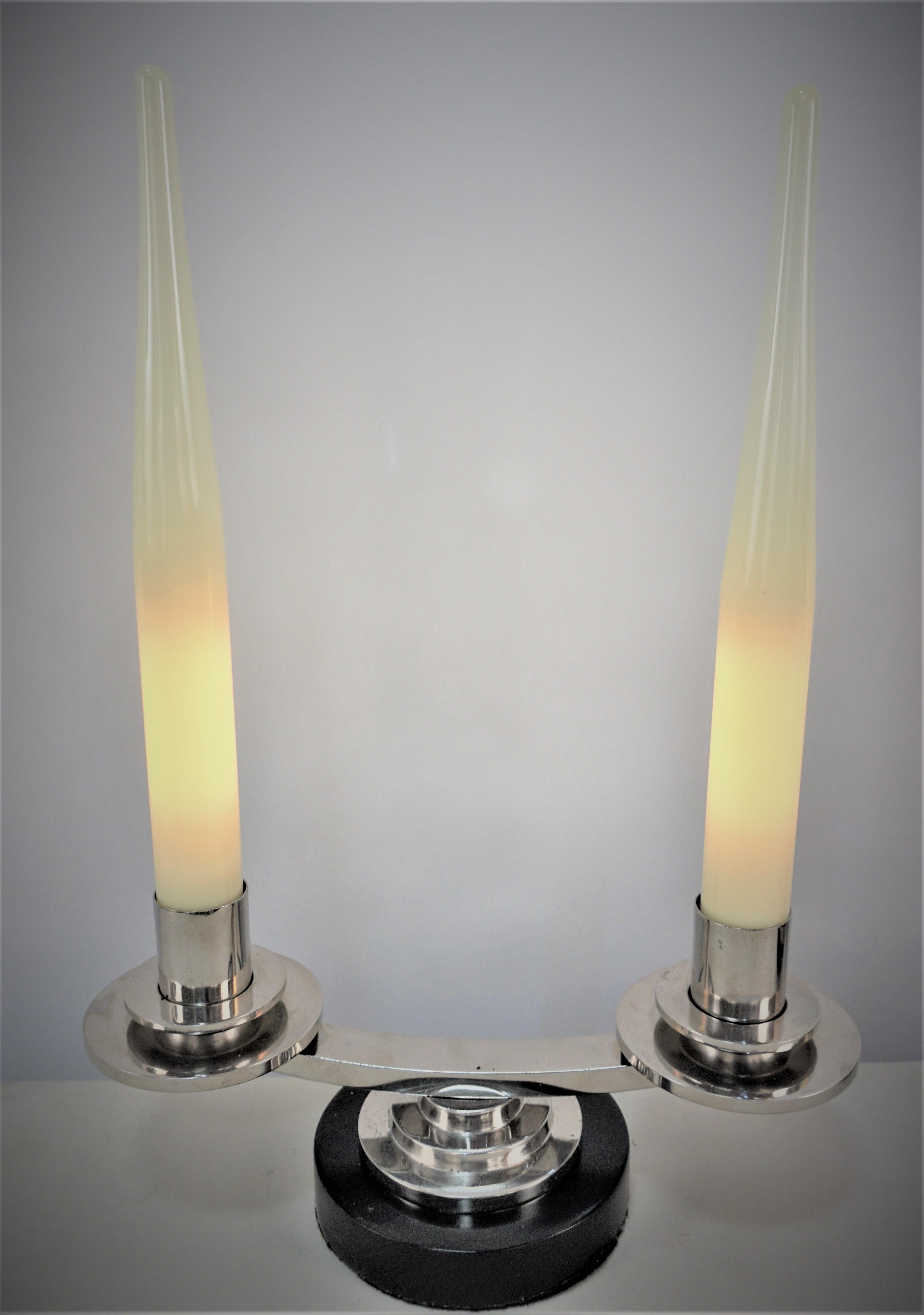 Paar doppelarmige einfache, aber elegante Kandelaberlampen aus Nickel auf Bronze mit lackiertem Holzsockel.
Diese Kandelaberlampen sind mit kerzenförmigem Glas ausgestattet, das jede Glühbirne abdeckt.