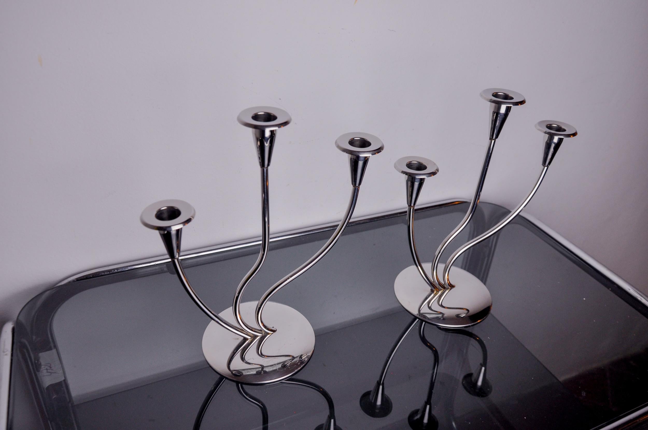 Sehr schönes Paar Art-Deco-Kerzenhalter aus rostfreiem Stahl, die in den 1970er Jahren in Spanien hergestellt wurden. Struktur aus rostfreiem Stahl 18/8, die 3 Kerzen aufnehmen kann. Hervorragendes Designobjekt, das Ihr Interieur wunderbar