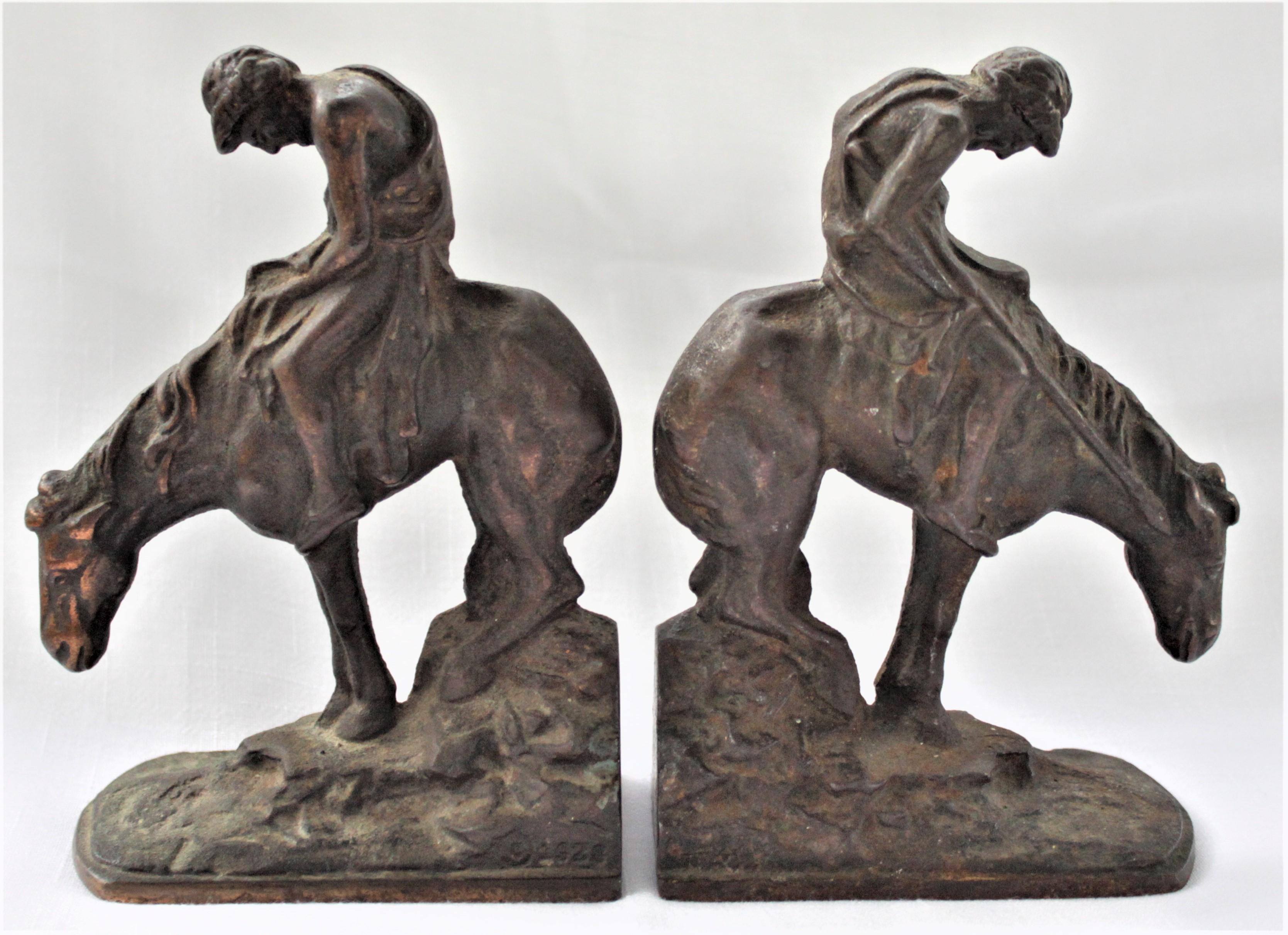 This set of cast and bronze finished metal sculptural bookends were made in 1928, presumably in the United States, in the American Colonial style. Each bookend does have a manufacturer's mark cast into it in a bottom corner, but deemed illegible and