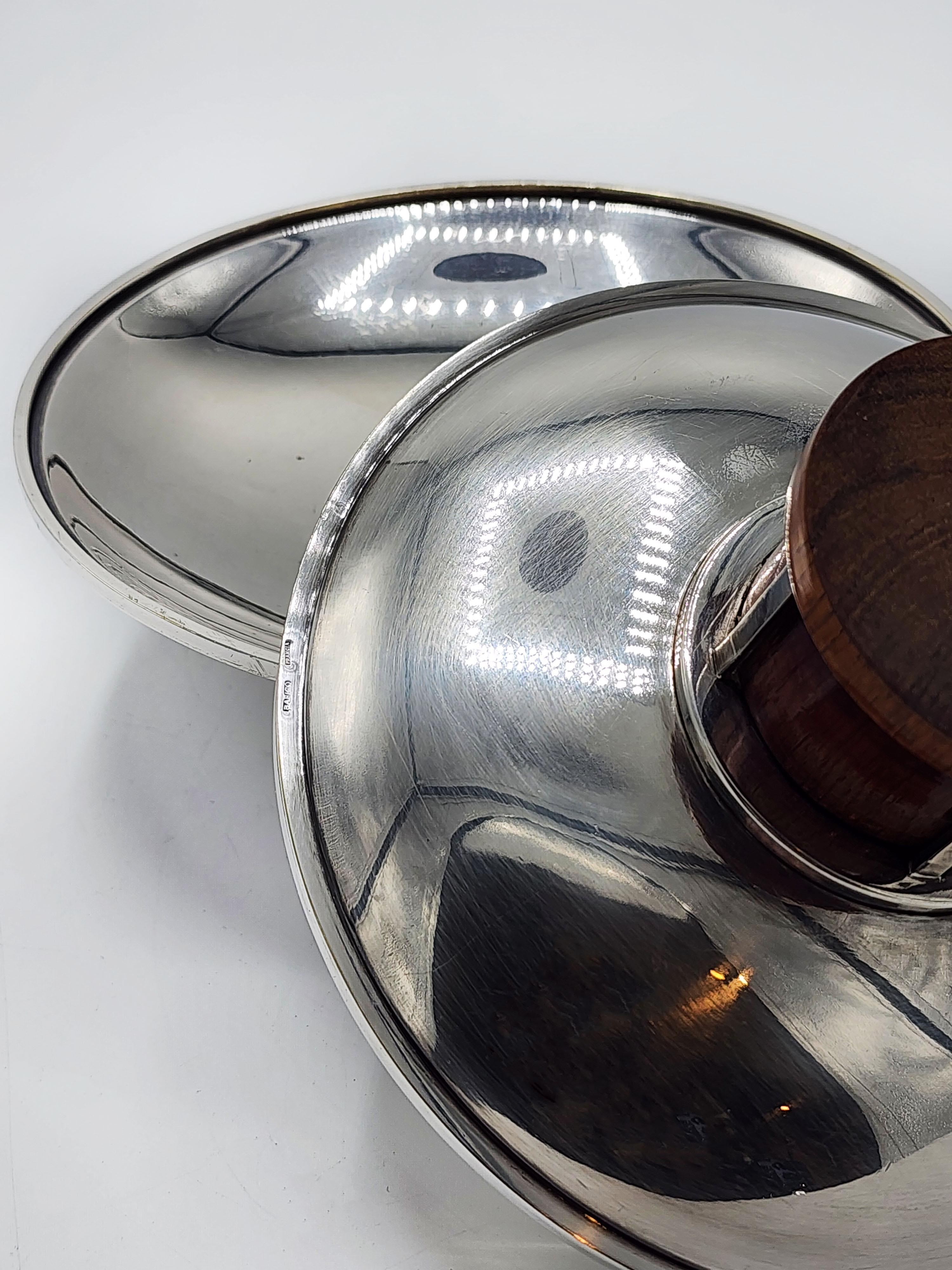 Pair of Art Deco centerpieces in silver metal and wood from Bafico, France
Elegant pair of art deco centers in silver metal with a mahogany wood base with a geometric line design
Measures:
Height: 6.6 centimeters
Diameter: 16 centimeters
