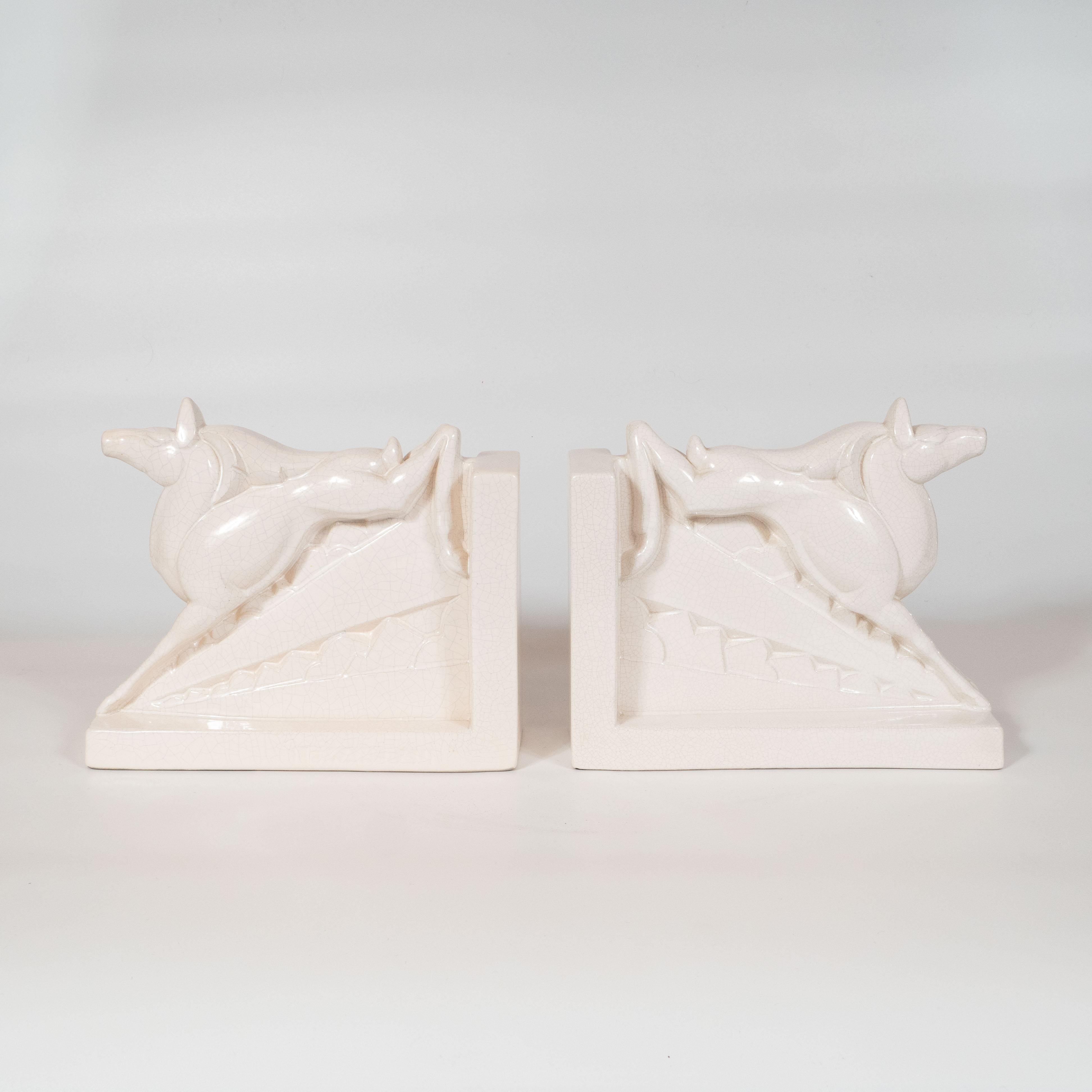 This lovely pair of bookmarks were realized by the esteemed maker Charles Lemanceau. They depict a horse outstretched across a flight of stairs, rendered in a style suggestive of a Classical Greek tableau. It has been realized in white glazed