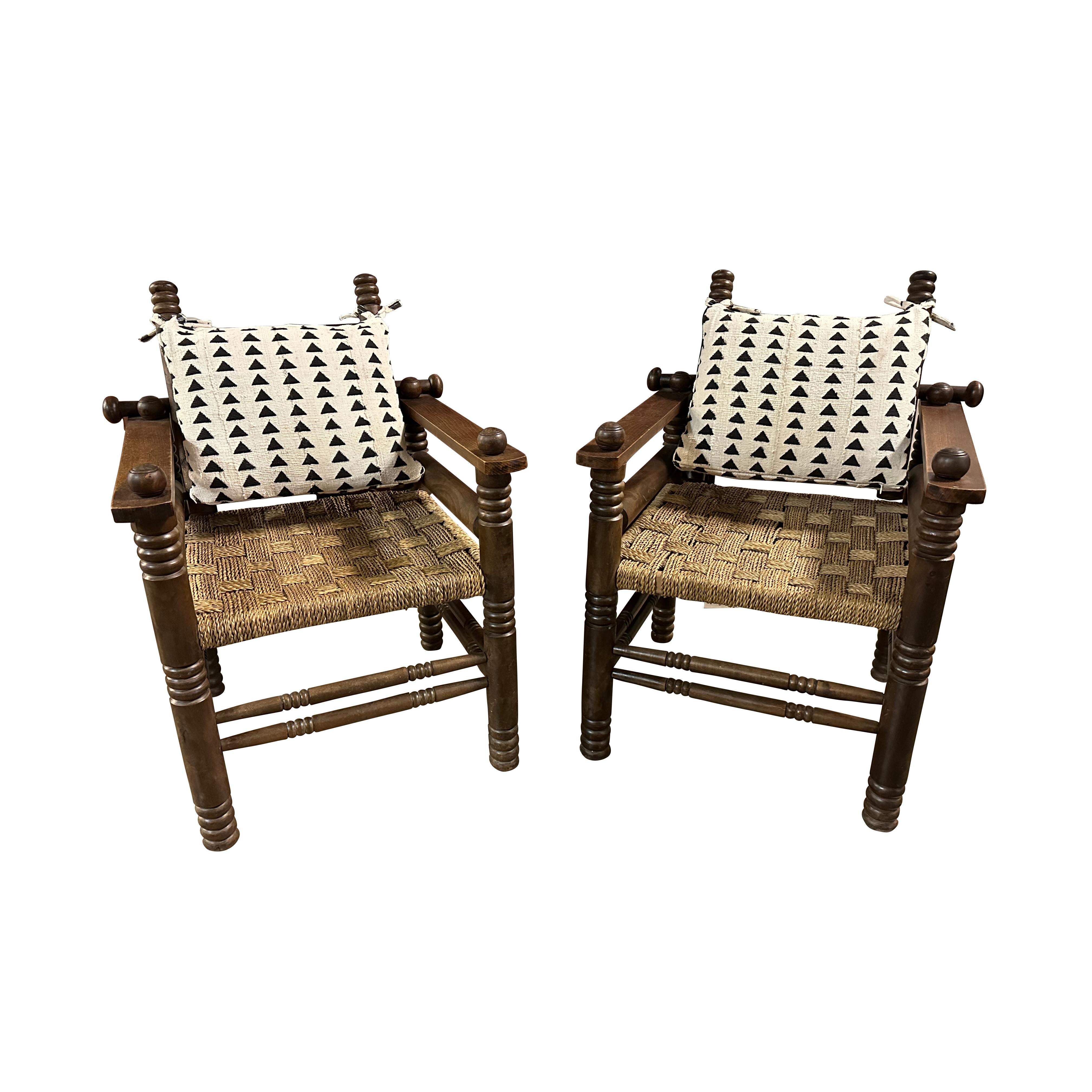 Pair of armed lounge chairs in the Art Deco style by collectible designer Charles Dudouyt. Well-crafted hardwood frames sport a woven rush seat. Ready for the addition of a custom back cushion. France, 1940s.