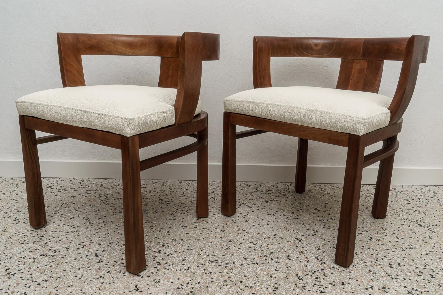 This stylish pair of mid-century moderd chairs are very much in the style of pieces created by Carl Bergsten. 
 
And the forms call on the Greek klismos back, and the legs have a Korean form.

The upholstery is a faux shagreen in naughahyde. 
