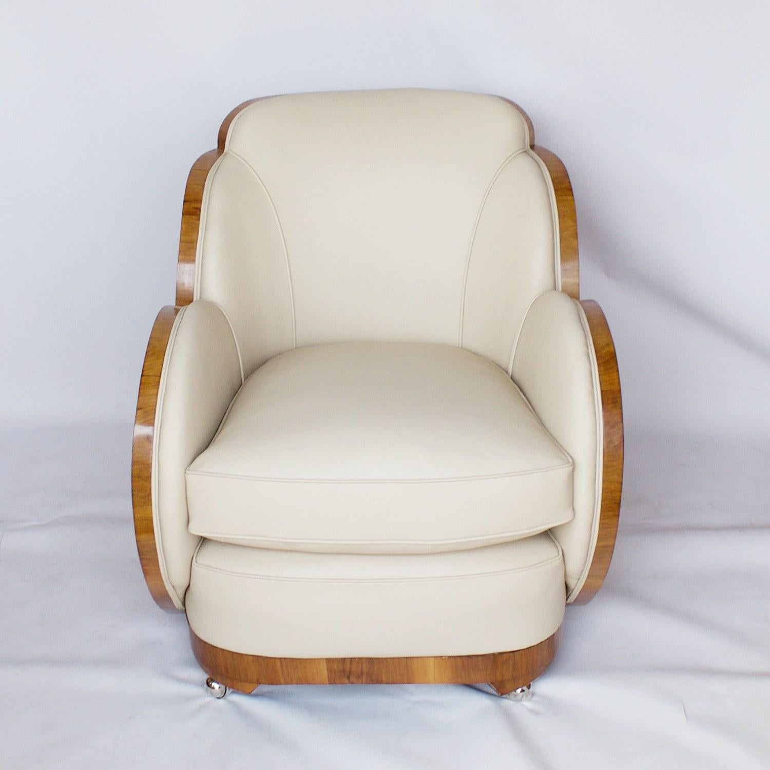 A pair of Art Deco Cloud chairs by Harry & Lou Epstein. Bleached figured walnut wrapped veneers with straight grain walnut banding. Set on modern replacement casters and re-upholstered in cream leather. 

Dimensions: H 80cm, W 75cm, D 95cm, seat H