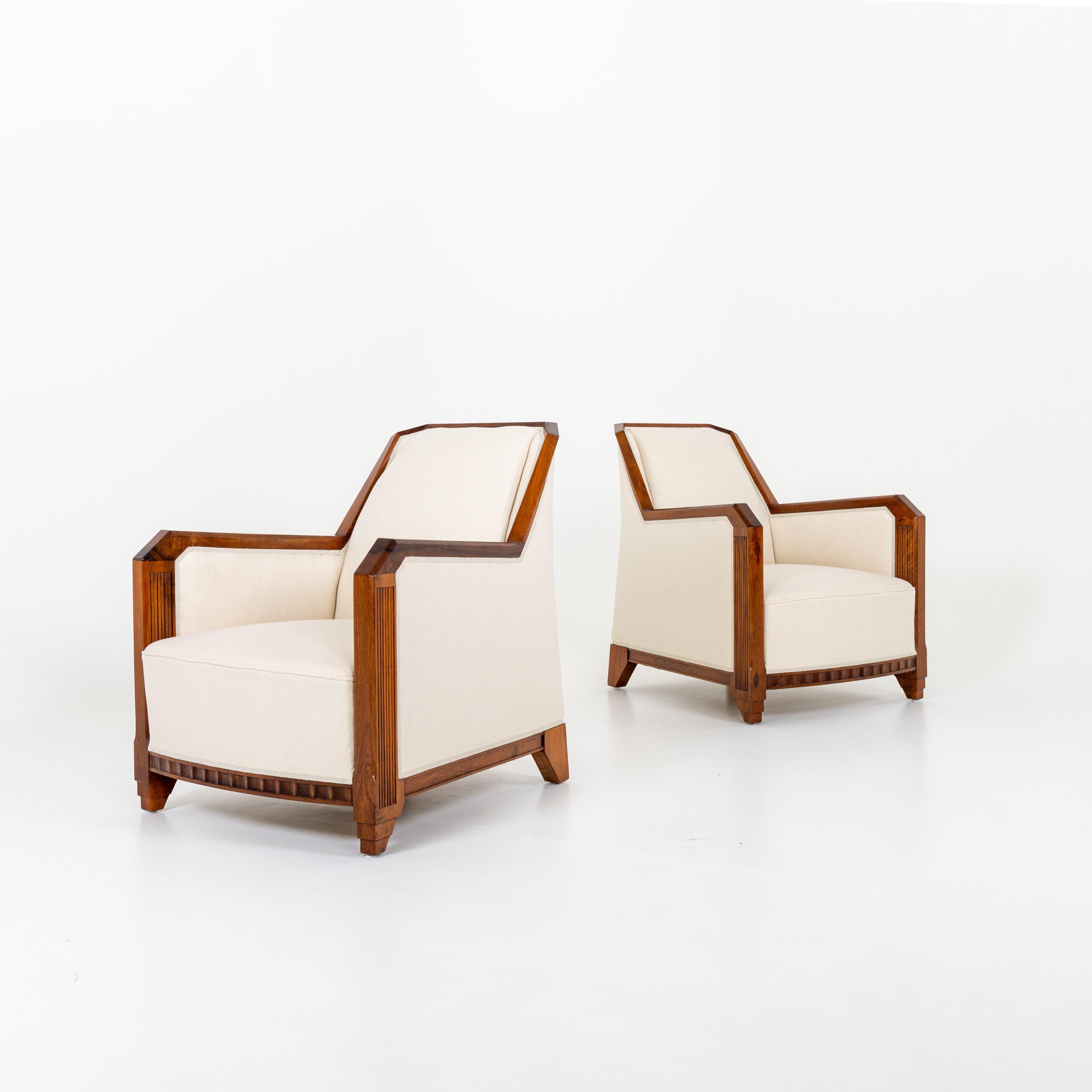 A pair of Art Deco club chairs attributed to Maurice Dufrene. 
Walnut with carved details.