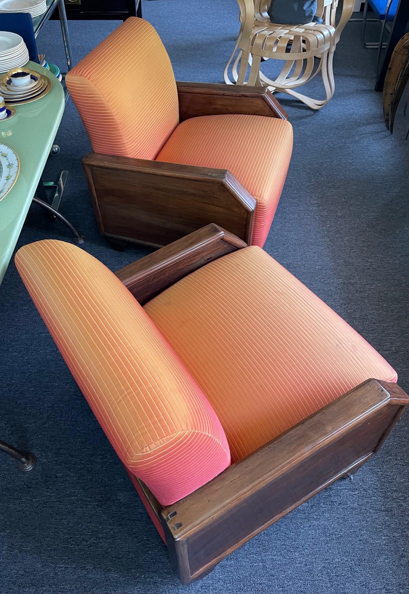 A pair of upholstered large French Art Deco club chairs. With their angular look and upholstered Art Deco inspired fabric, these arm chairs inspired by the style of Emile-Jacques Ruhlmann are beautiful from the 1930s and very comfortable with a seat