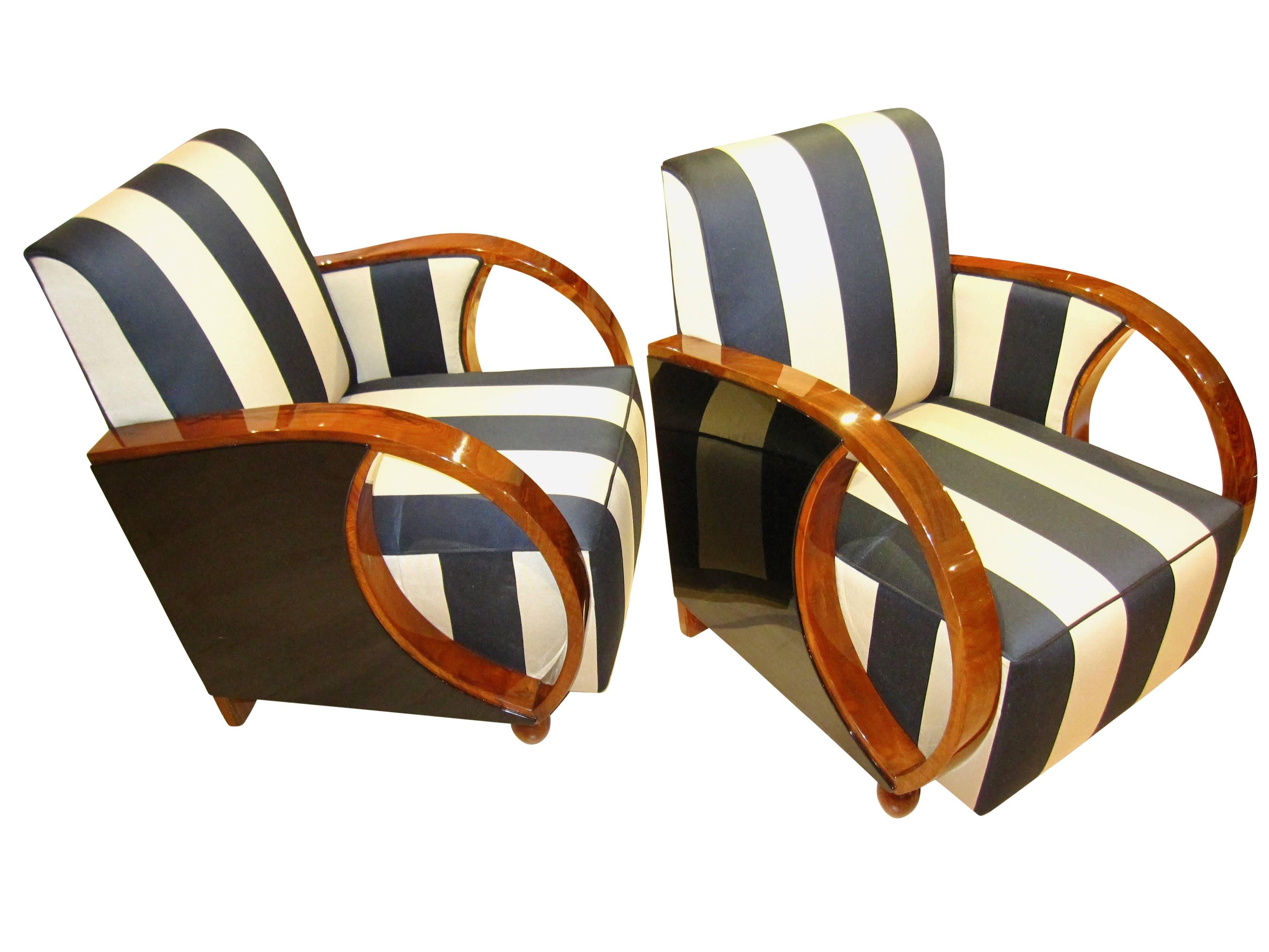 Very elegant pair of Art Deco Club Chairs/Bergere Chairs from France about 1930. The wood is walnut veneer with an ebonized/blackened polished wood plate on the side. They are newly upholstered with a broad stripe classic fabric from JAB Anstoetz