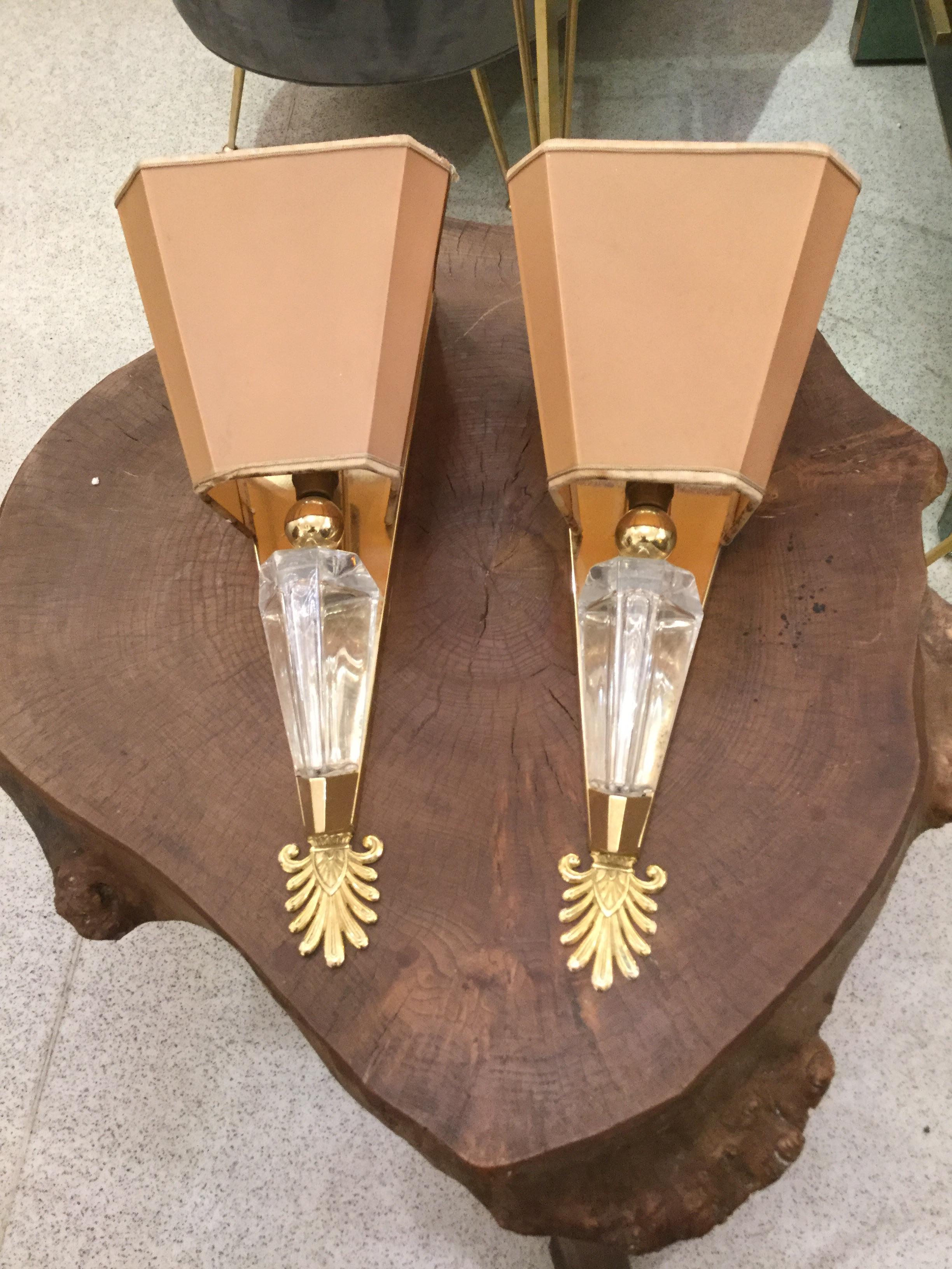 An elegant pair of sconces in crystal mounted on a gilt-metal fixture.
 With original shades.