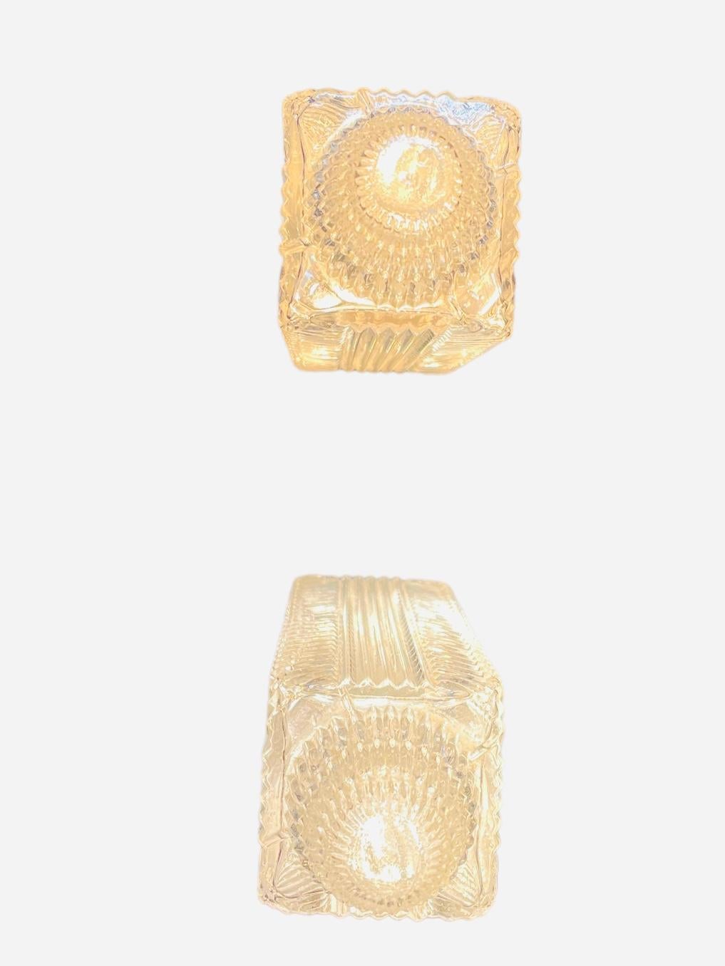 Il s'agit d'une paire de lampes de table électrifiées en cristal taillé. Il représente un abat-jour de forme rectangulaire soutenu par un triple corps métallique à anneaux gradués, qui repose sur une base ronde en cristal nervuré avec des bordures