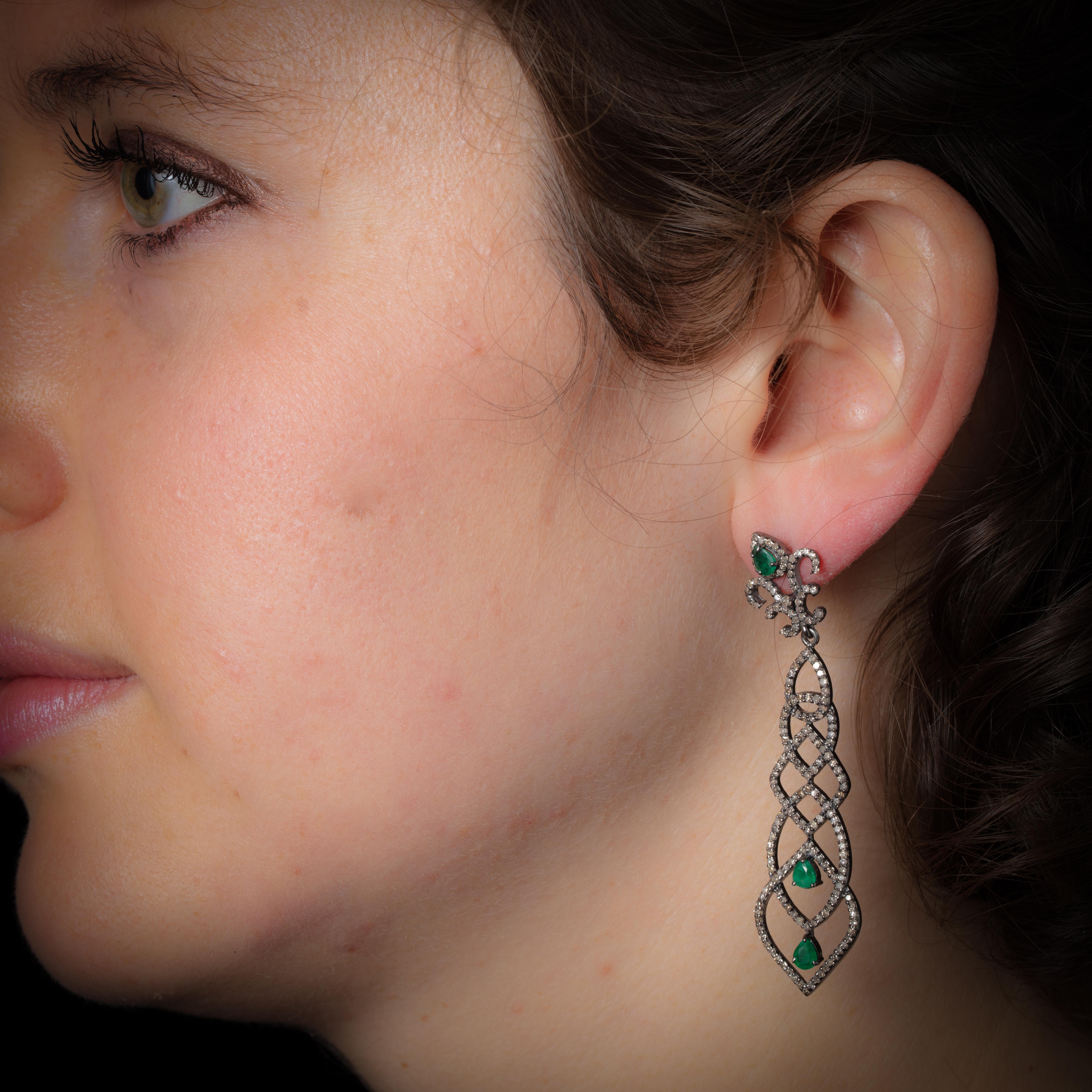 With a nod to Art Deco architecture, a pair of pave`-diamond and faceted pear-shaped emerald earrings.  Set in an oxidized sterling silver with an 18K gold post for pierced ears.  Weight of diamonds is 2 carats and emeralds are 1.10 carats.  