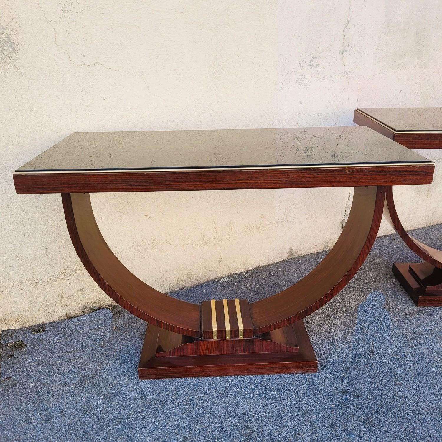 Pair of wooden display consoles with a black glass top, Art Deco 

Very elegant model, in shape and composition: the veneer pattern is enhanced with gilded bronze rods  

Light traces of use  

Height 79cm
 110 x 55cm