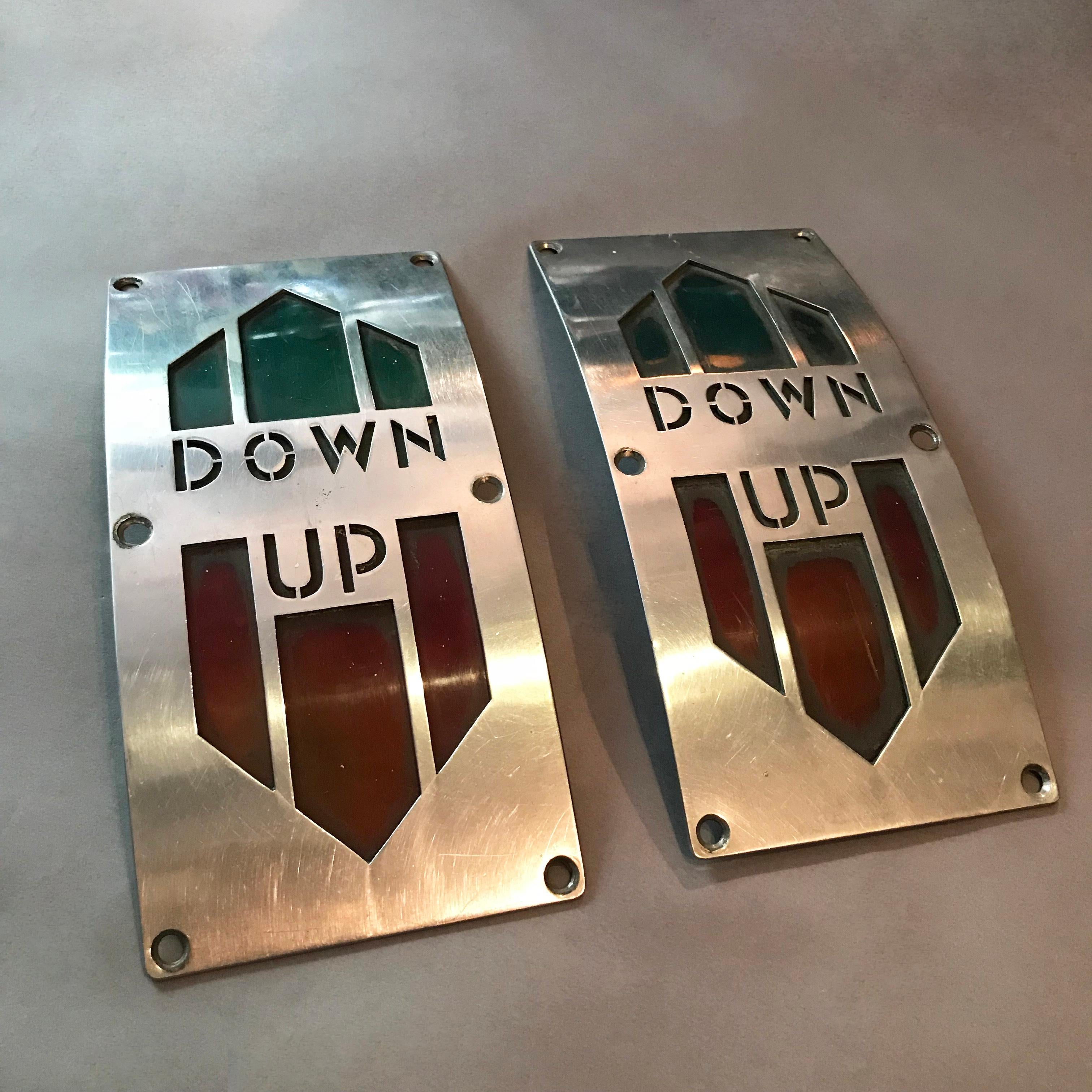 Pair of wonderful, Art Deco, up down, direction elevator panels feature a curved nickel-plated brass frame with green and red celluloid backing.