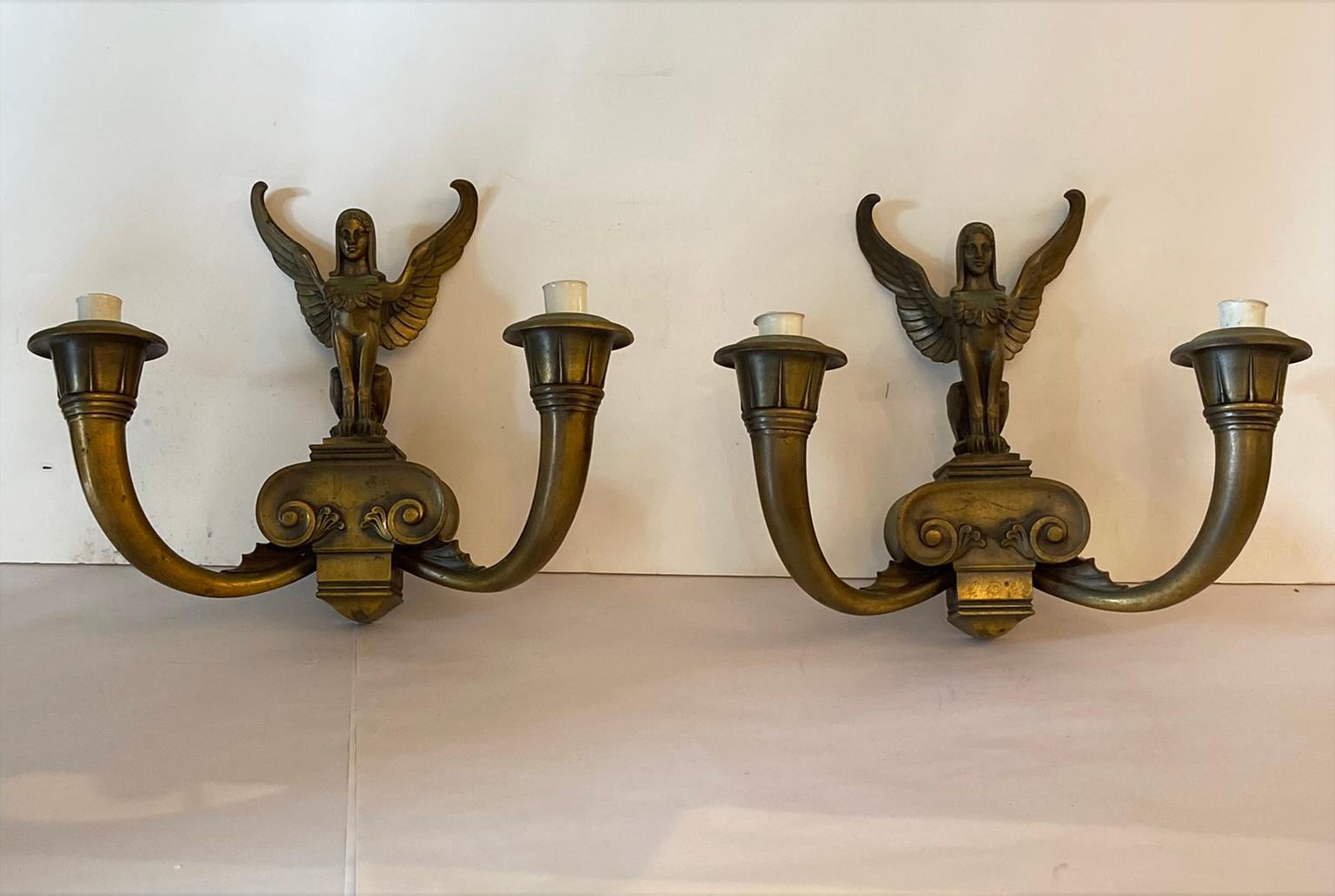 An intriguing pair of sconces from the art deco period… incredible detail cast in bronze ..each winged figure holding two lights.. And original bronze patina with no restorations… Very good condition