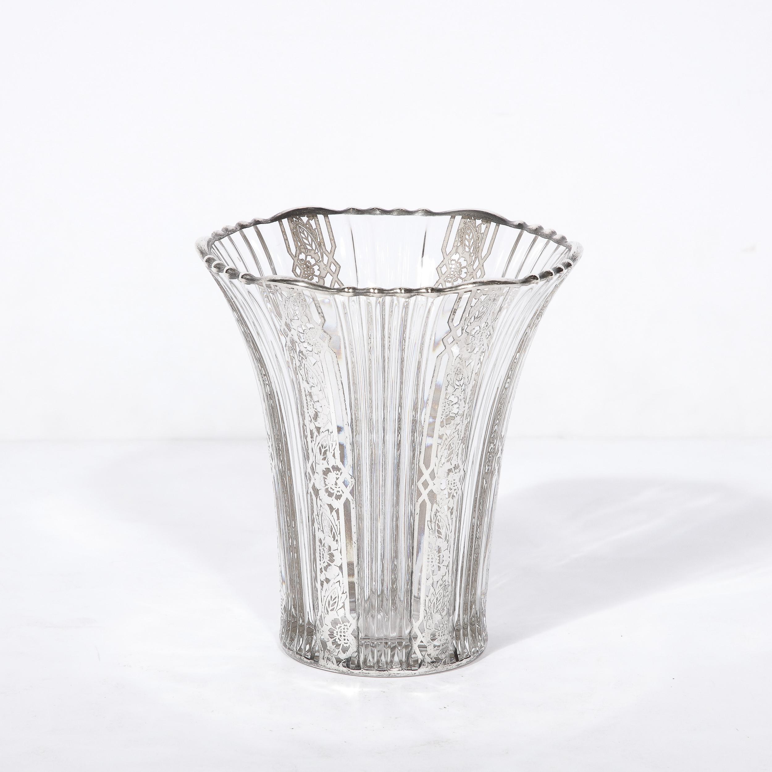 Crafted in the United States circa 1930, with an Art Deco geometric sterling silver overlay that adorns the rippling edges of the top and bottom of the vases, this pair is a lovely example of vases from the era. Decorative details of natural imagery