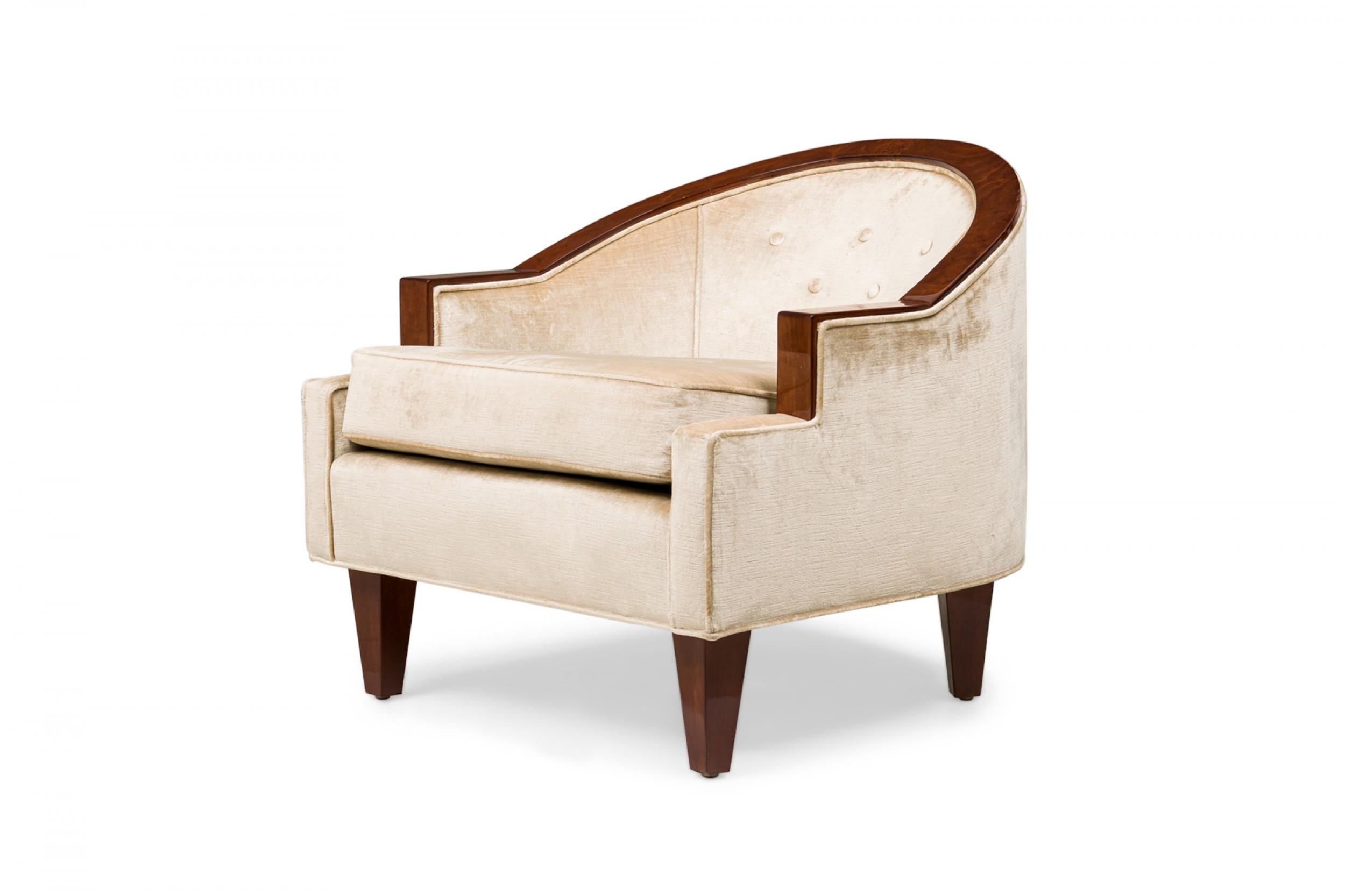 Pair of Art Deco French mahogany tub / parlor chairs in a bergère style with a low curved horseshoe back, step back arms, tufted beige upholstery in a satin finish with piping and removable seat cushion and resting on 4 tapered square legs (PRICED