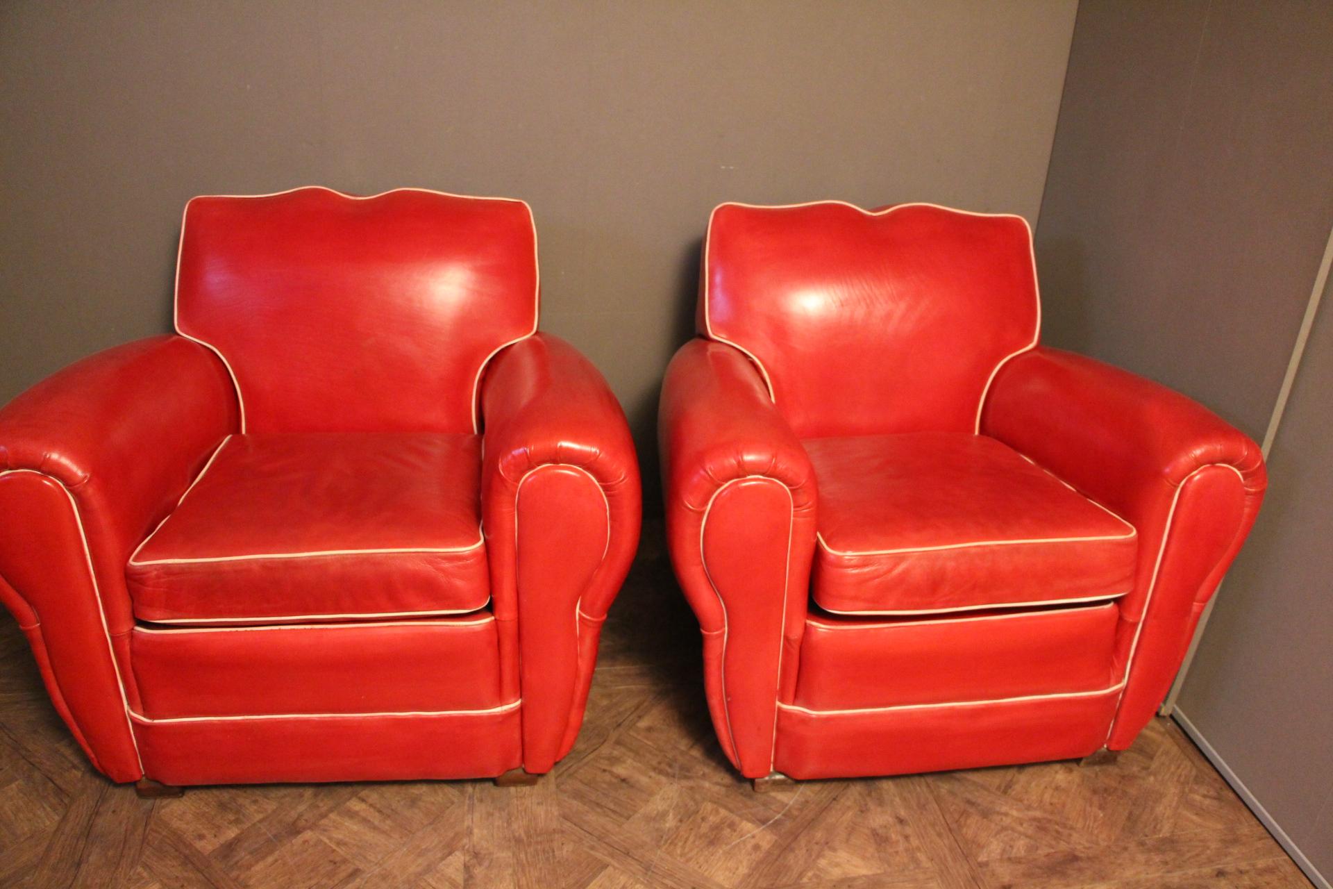 This pair of French club chairs features a vibrant poppy red color and a very nice mustache shaped back.
Separate seat cushions (new foam).White leather trim around and studs all around their backs.
They are perfectly original and in very good
