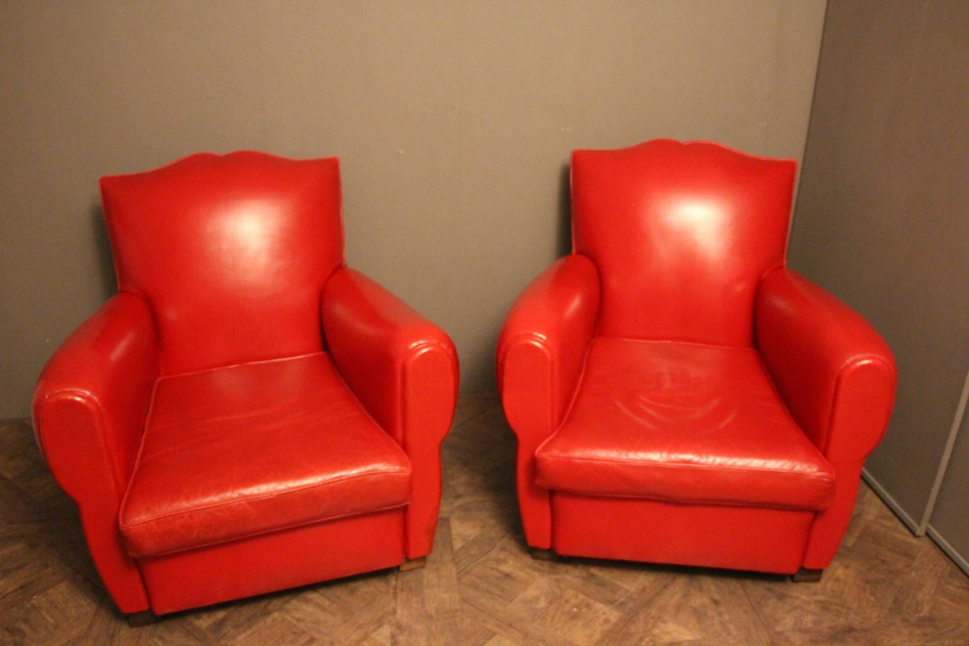 This pair of French club chairs features a vibrant poppy red color and a very nice mustache shaped back.
Separate seat cushions. Red leather trim around and studs all around their backs.
They are perfectly original and in very good condition.