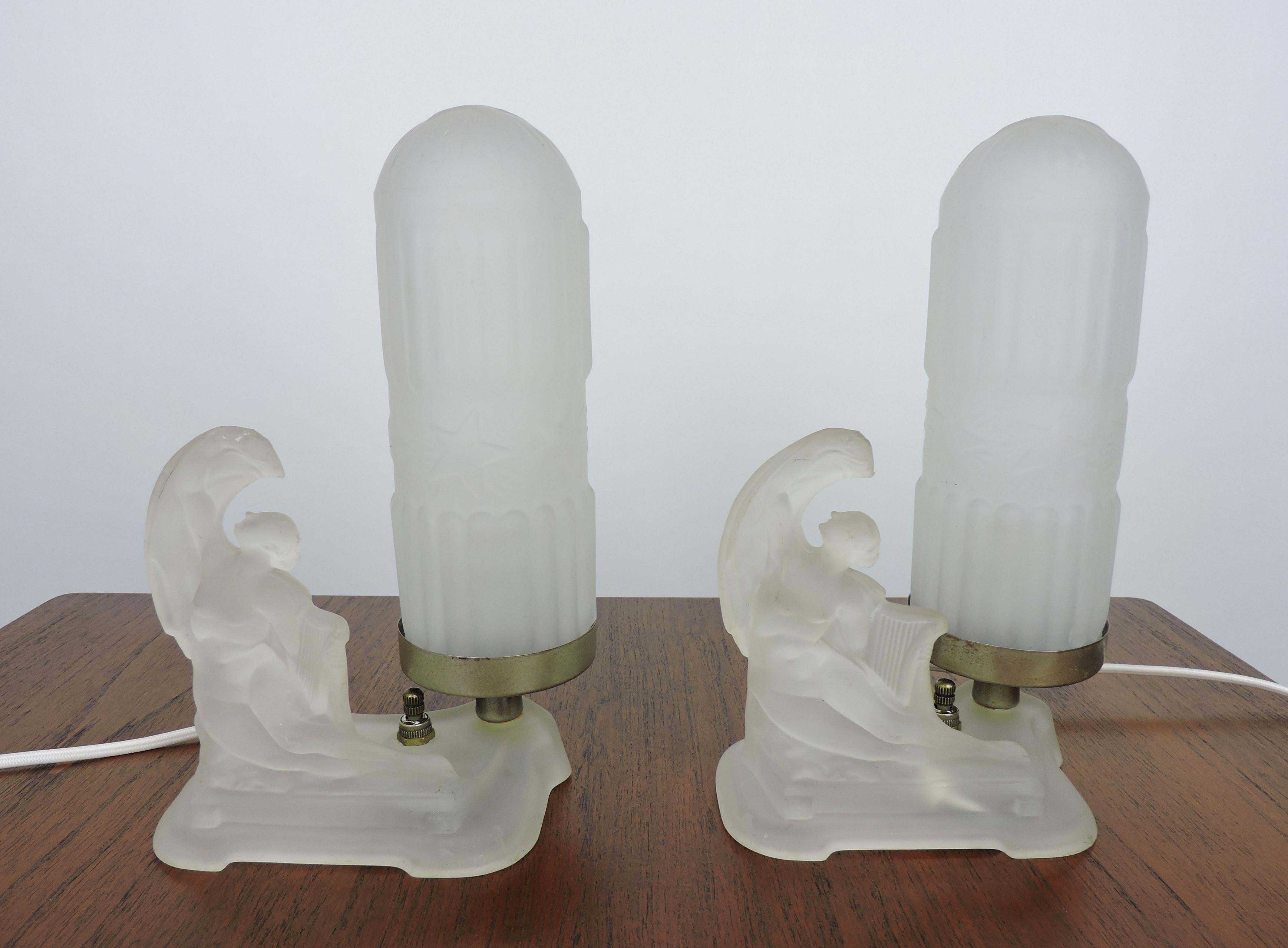 Beautiful pair of Art Deco boudoir table lamps with frosted glass nudes holding lyres attributed to McKee Glass Company of Pittsburgh. These have all new wiring with cloth covered cords. The frosted bullet shades are not original to the lamps, but