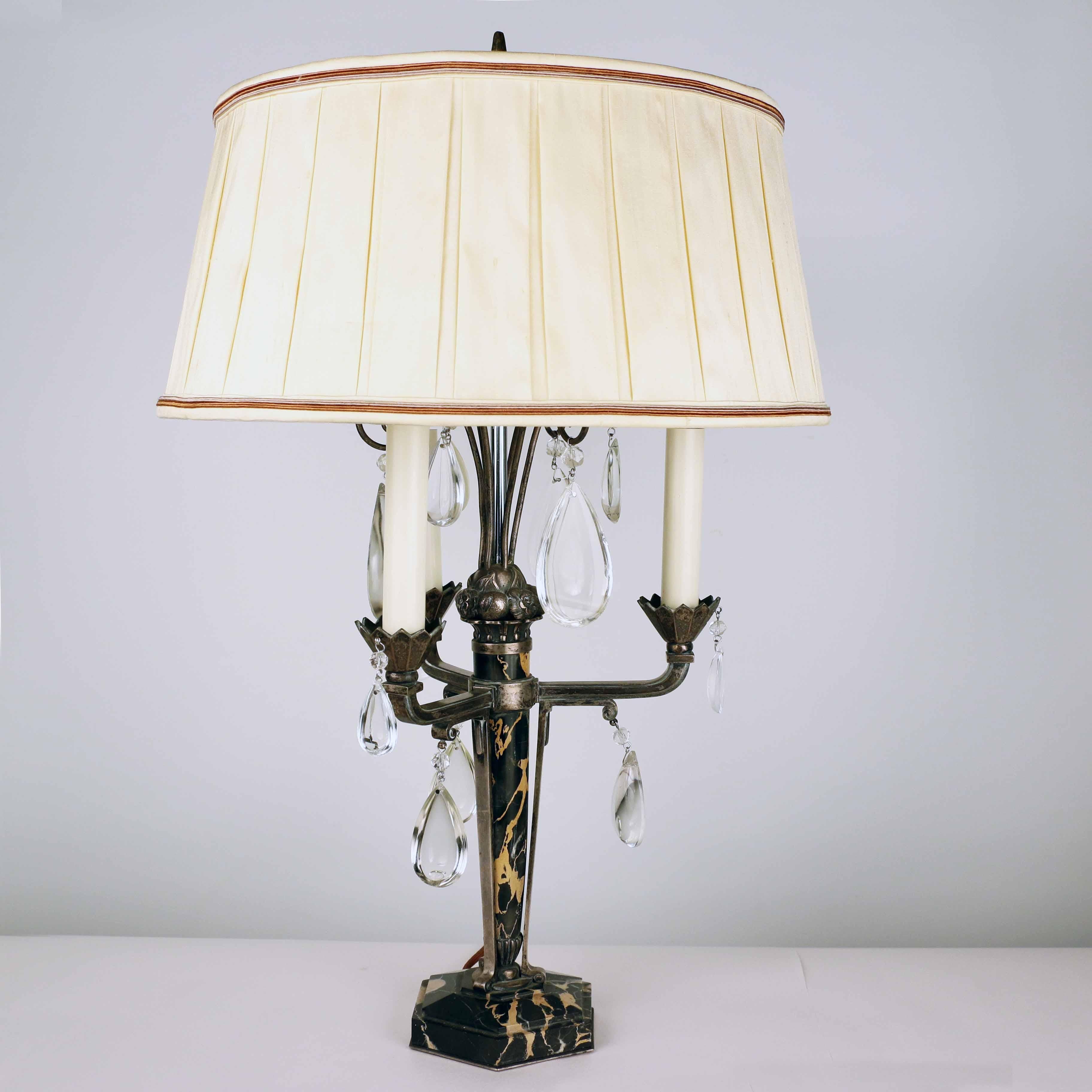 Pair of Art Deco marble and silvered bronze three light girandoles with half pear crystals, later converted to electricity, and their custom pleated silk shades.