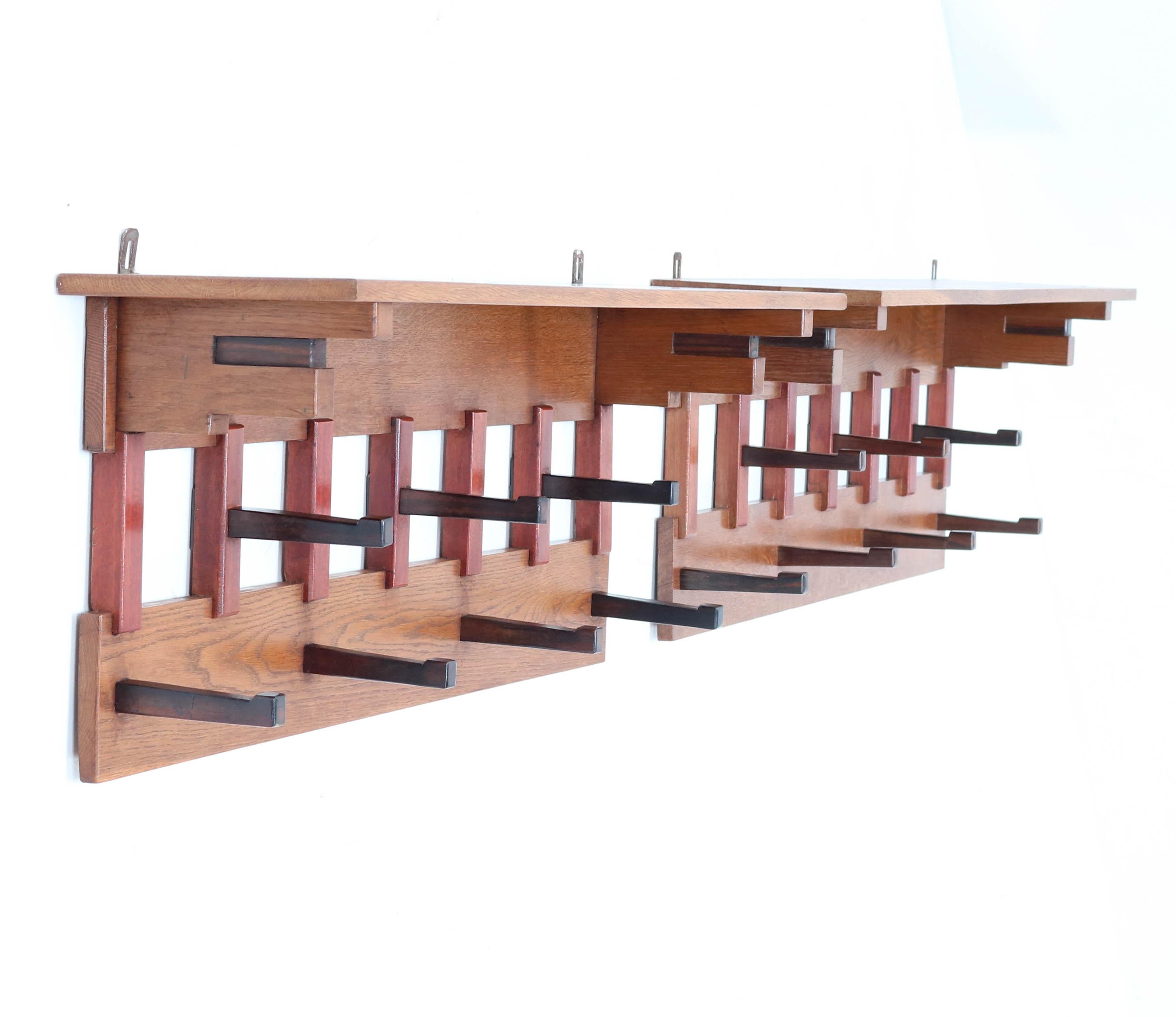 Magnificent and rare pair of Art Deco Haagse School coat racks.
Design by P.E.L. Izeren for Genneper Molen.
Striking Dutch design from the 1920s.
Solid oak with solid Macassar ebony hooks and solid mahogany lining.
In very good original