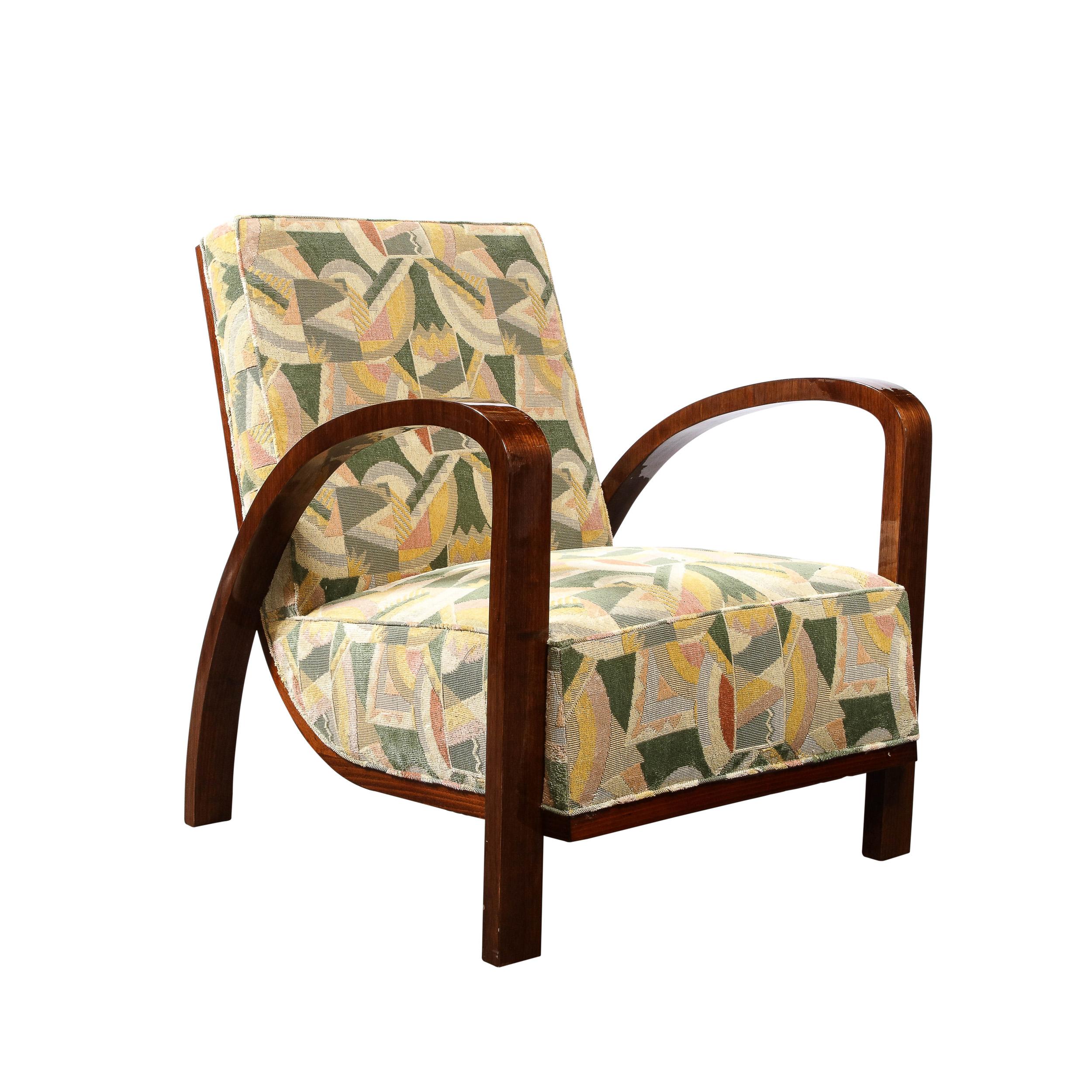 This stunning Pair of Art Deco Halabala Arm Chairs in Walnut & Clarence House Upholstery originate from France, Circa 1935. They feature gorgeously curved arm rests in sculpted walnut that serve to support the main body of the chairs. The body of