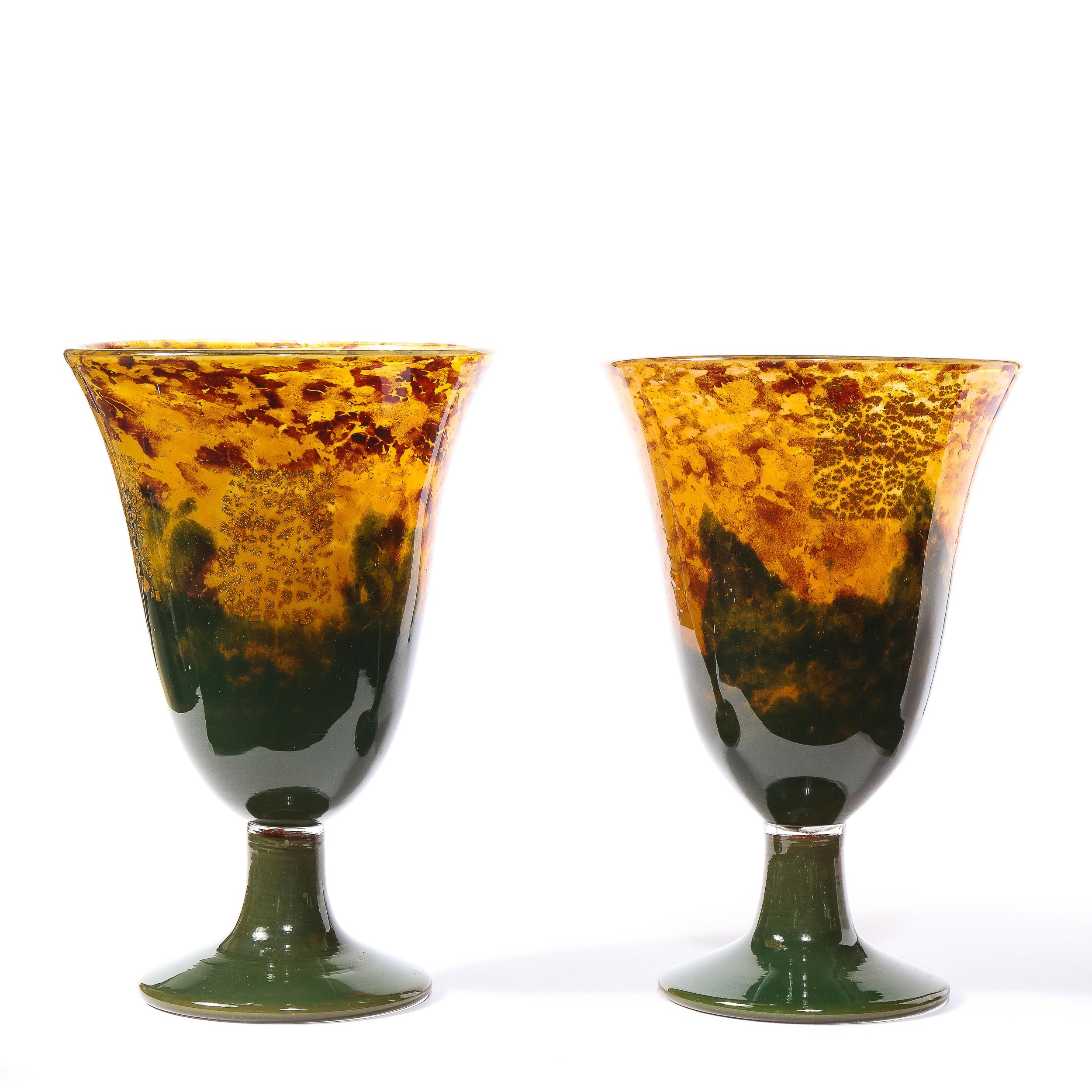 This refined pair of Art Deco vases were realized and signed Nancy Daum in France circa 1920. They offer billowing conical bodies in hand blown mottled glass with hues of saffron, emerald and ruby throughout. With their sumptuous glass quality and