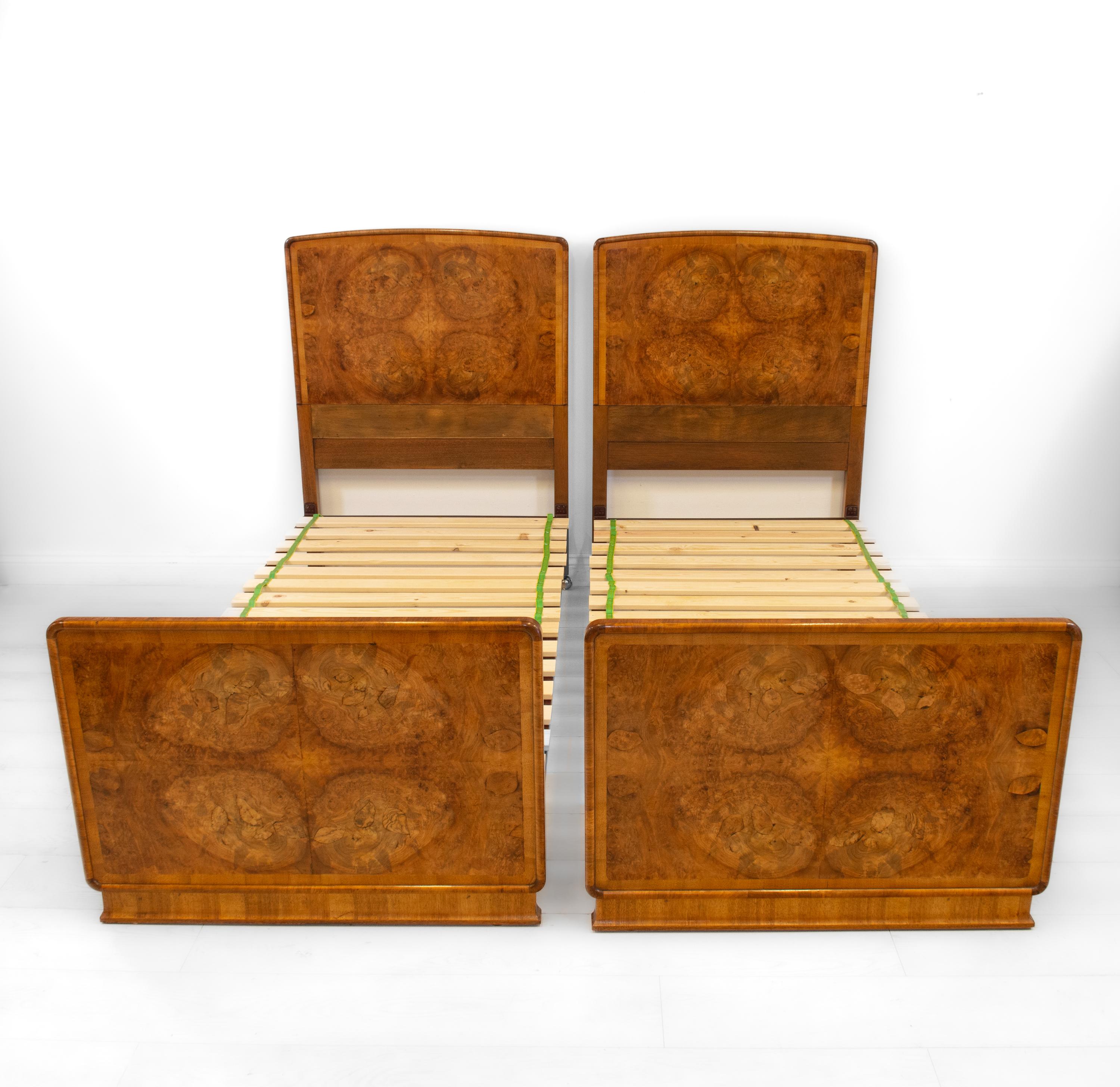 A superb pair of Art Deco burr walnut 3ft single beds, complete with side irons and wooden slats. Retailed by Harrods, London. Labelled. Circa 1930.

The headboards and the fronts of the footboards are superbly veneered in highly figured burr