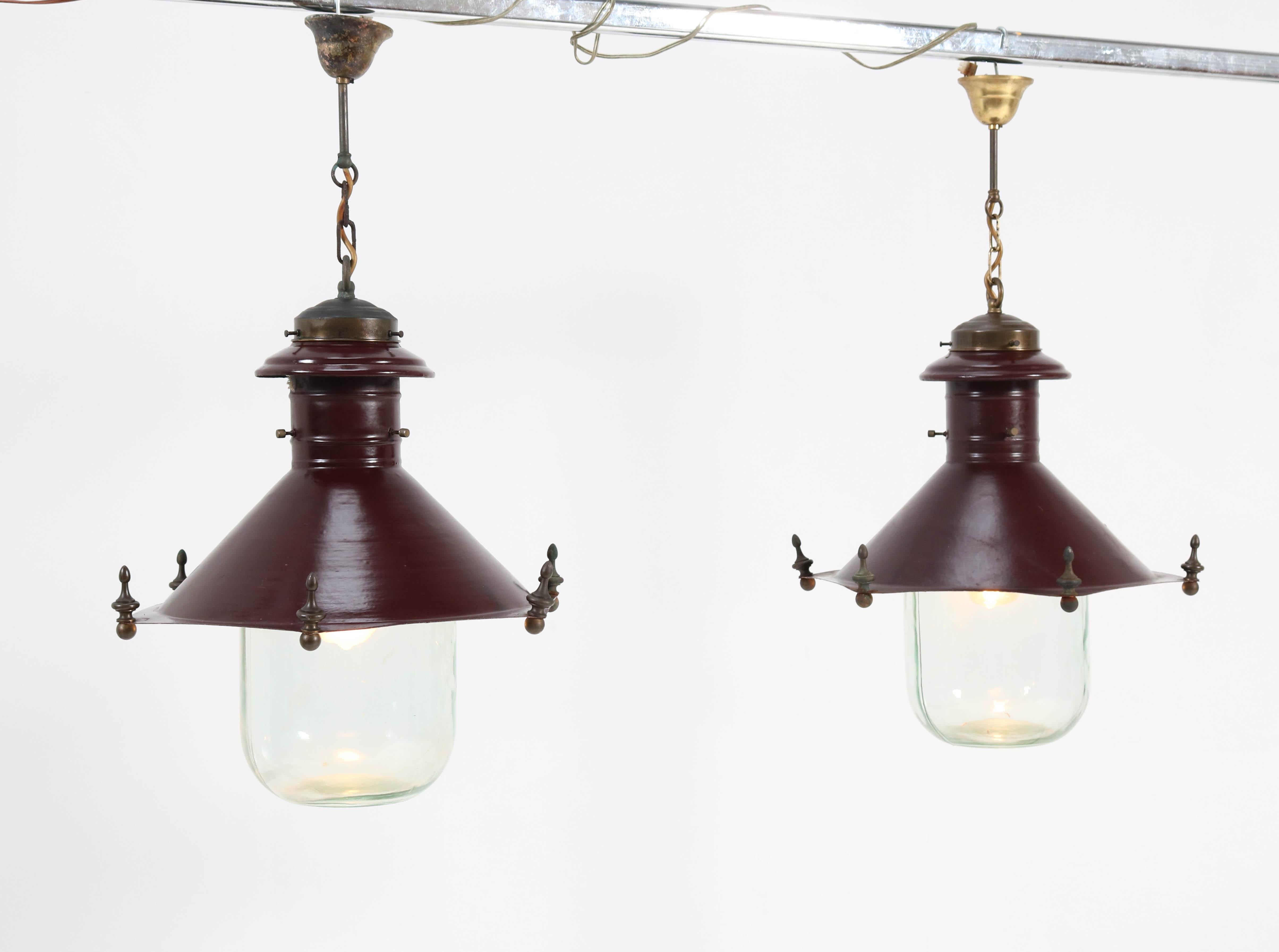 Stunning and rare pair of Art Deco Industrial lanterns.
Striking Dutch design from the 1930s.
Lacquered metal frames with patinated brass chains.
Two original glass shades with etched manufacturers mark.
In good original condition with minor