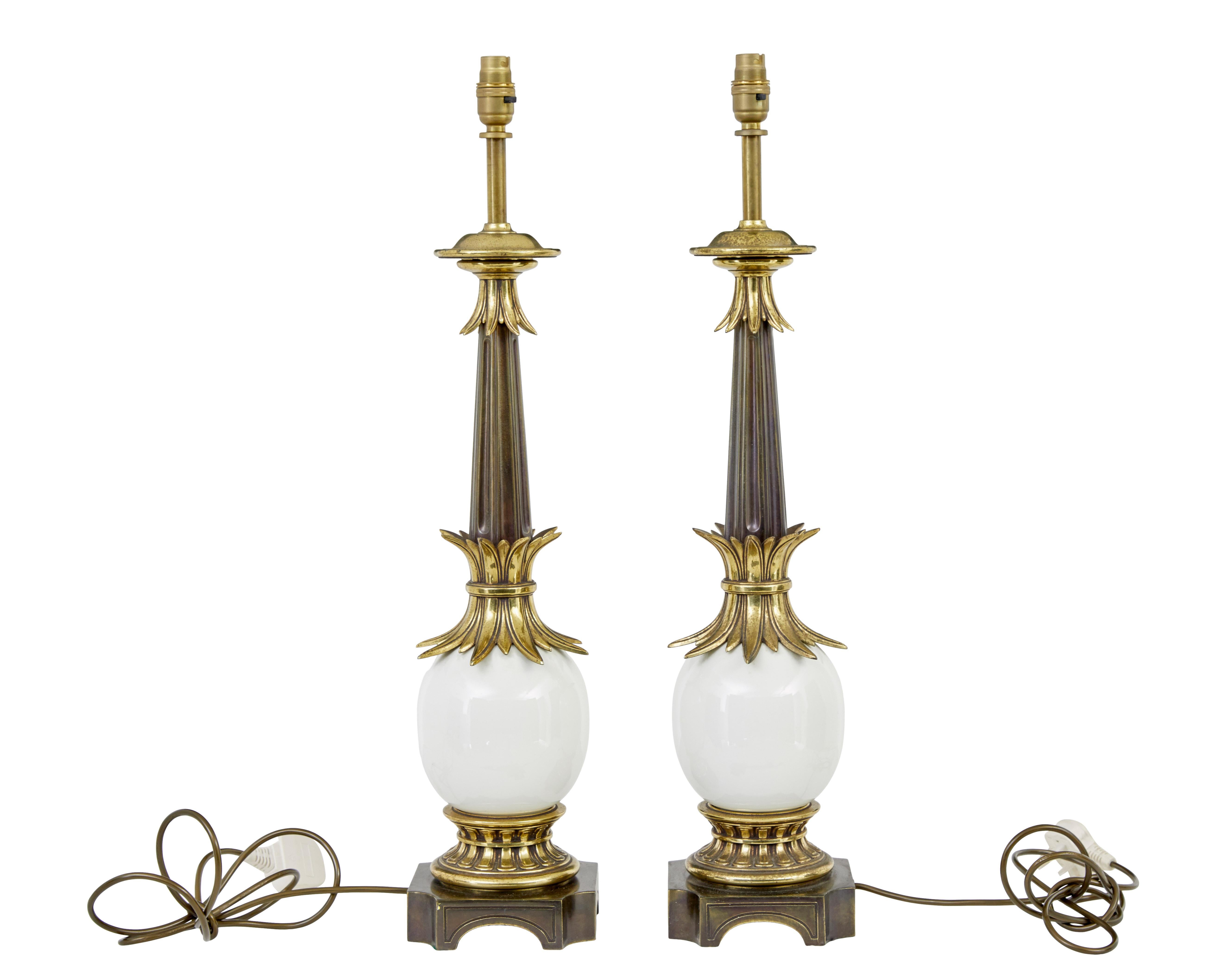 Pair of art deco influenced brass and glass table lamps circa 1990.

Bold pair of table lamps very much in the taste of the rich indulgent age of deco.  Brass bail of corn decorations with fluted bronzed stem.  Main feature being the large egg