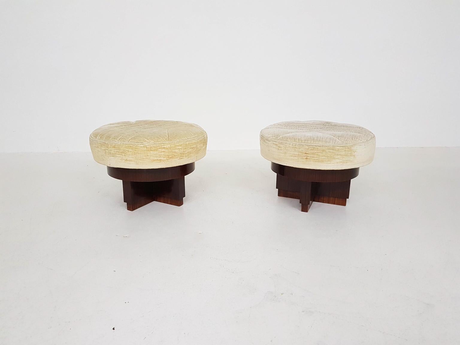 A pair of geometric, cross shaped wooden ottomans, poufs or stools from 1930s. Made in Italy.

The ottoman has a comfortable round cushion and a cross shaped base consisting of different layers of wood. Those layers create some depth to the